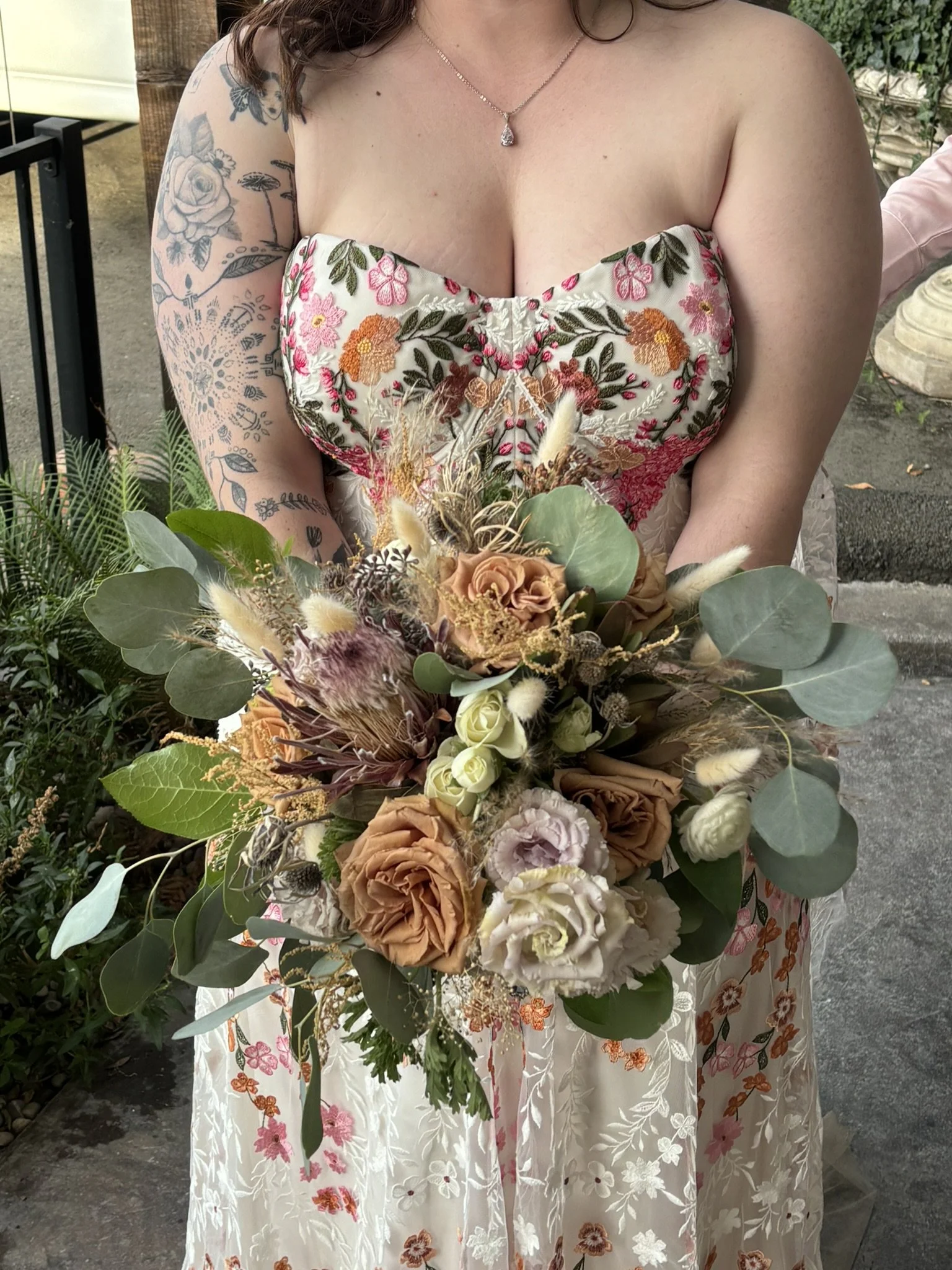 Detail image of bridal bouquet with fall boho colors with Pampas grass, protea, and toffee roses.