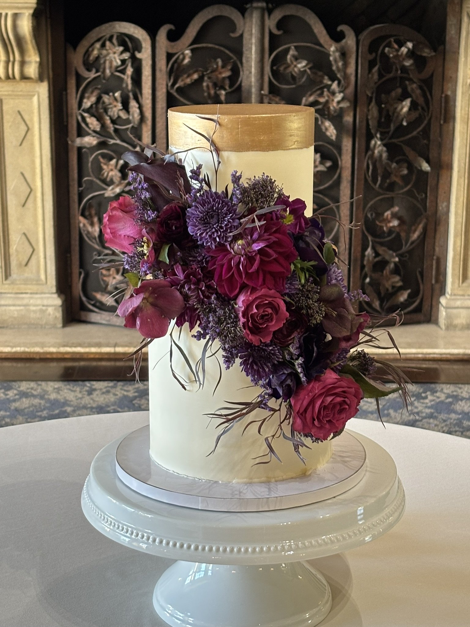 Cake decor with purple flowers cascading down the side of cake.