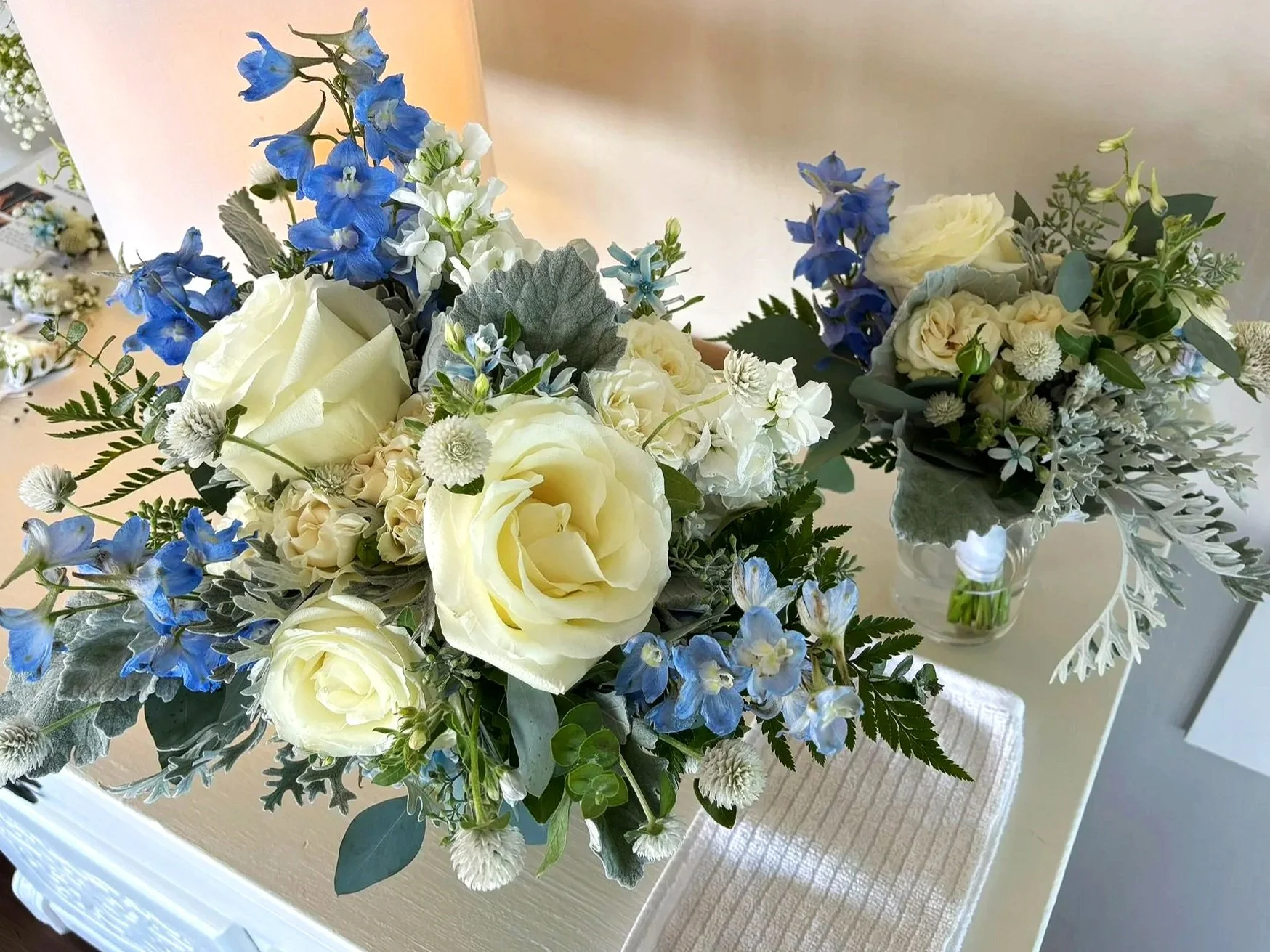 Detail of the bridal bouquet with white roses, blue delphinium.