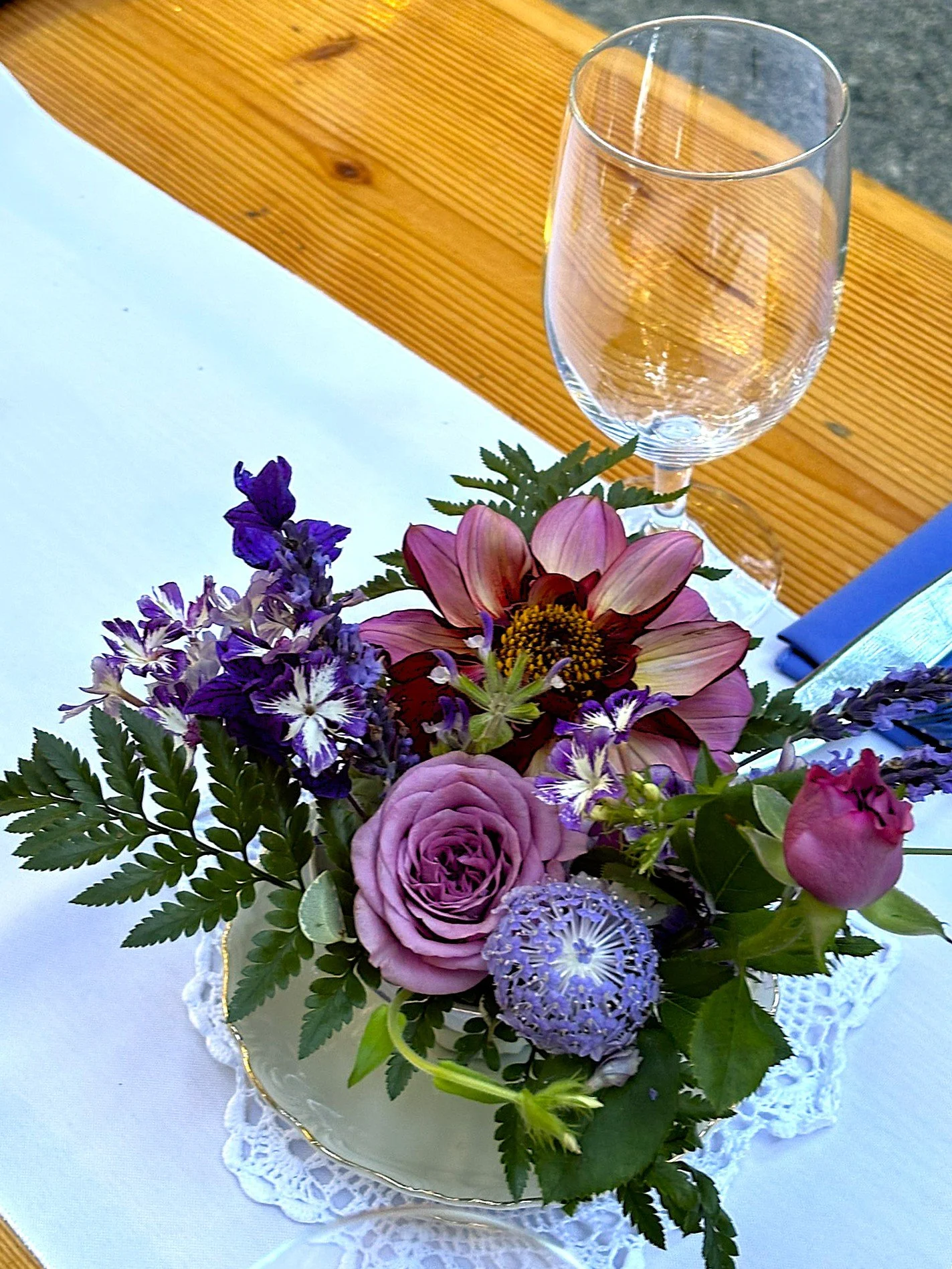 Detail of teacup centerpiece in blue tones with seasonal flowers.