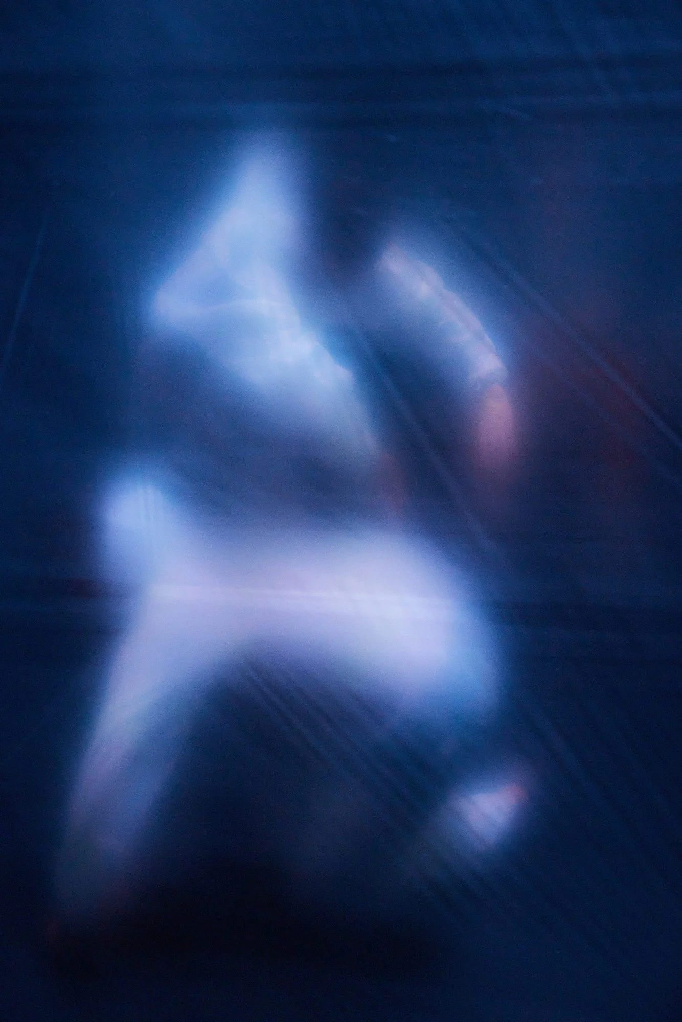 ULTRA WHITE: two figures in motion blur against a dark blue background
