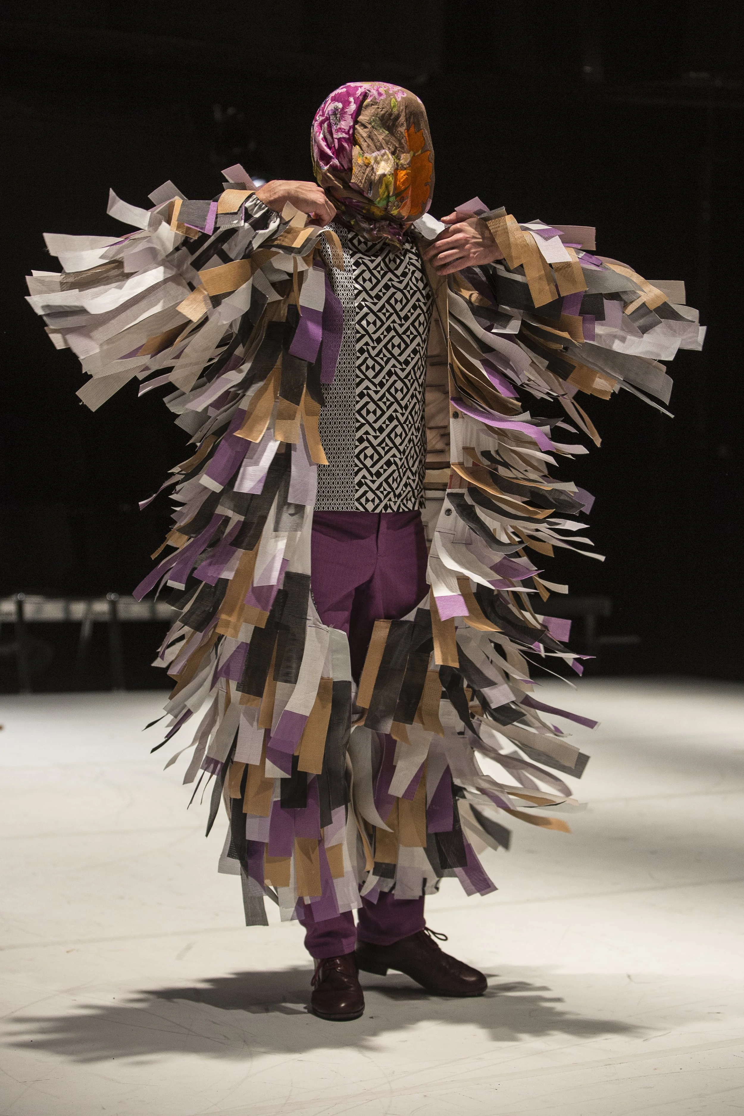 Gyula Cserepes in Creature by Cie József Trefeli, in a costume of layered, recycled plastic pieces