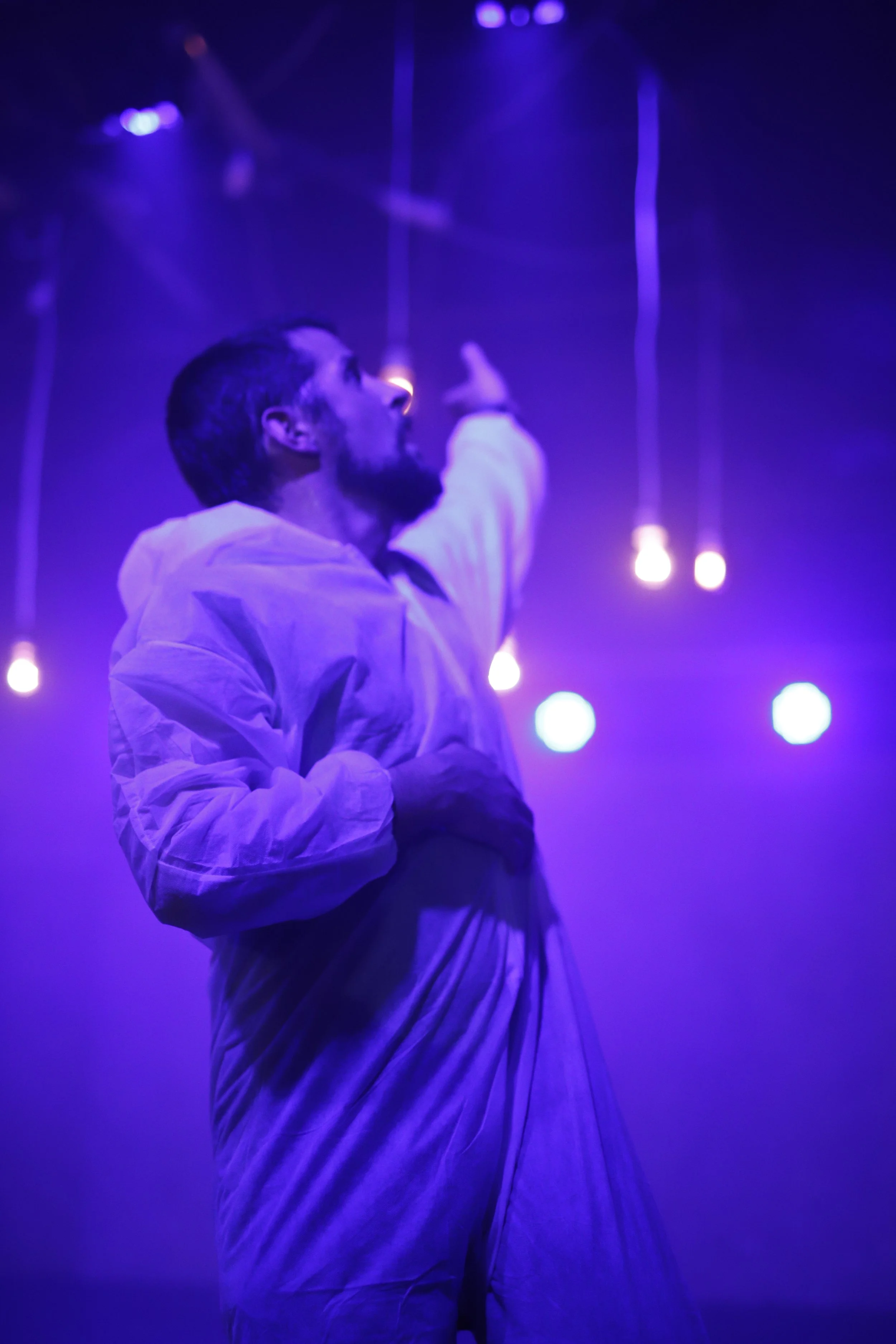 Gyula Cserepes in sevenTHseven, wearing a translucent white coat under violet light