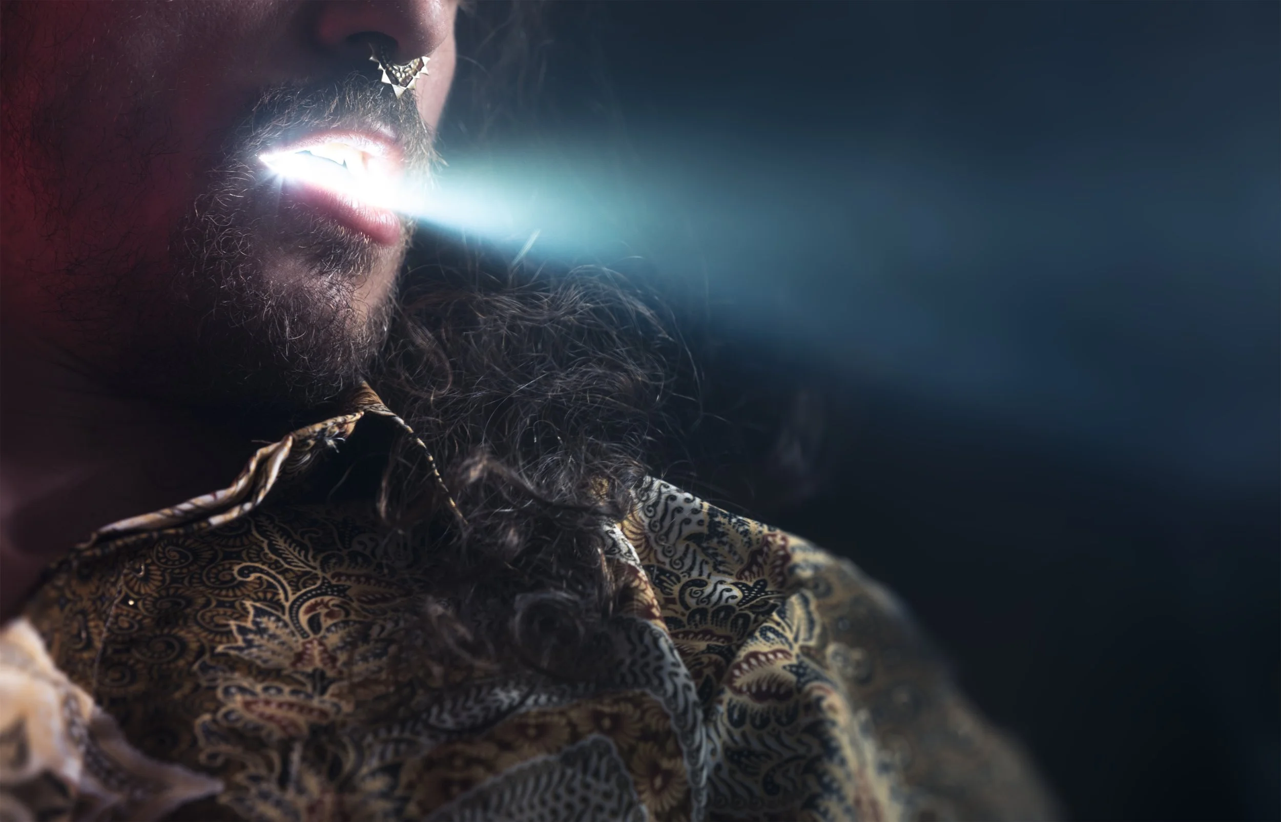 Rave: close-up of a performer's face, a beam of light coming from the mouth