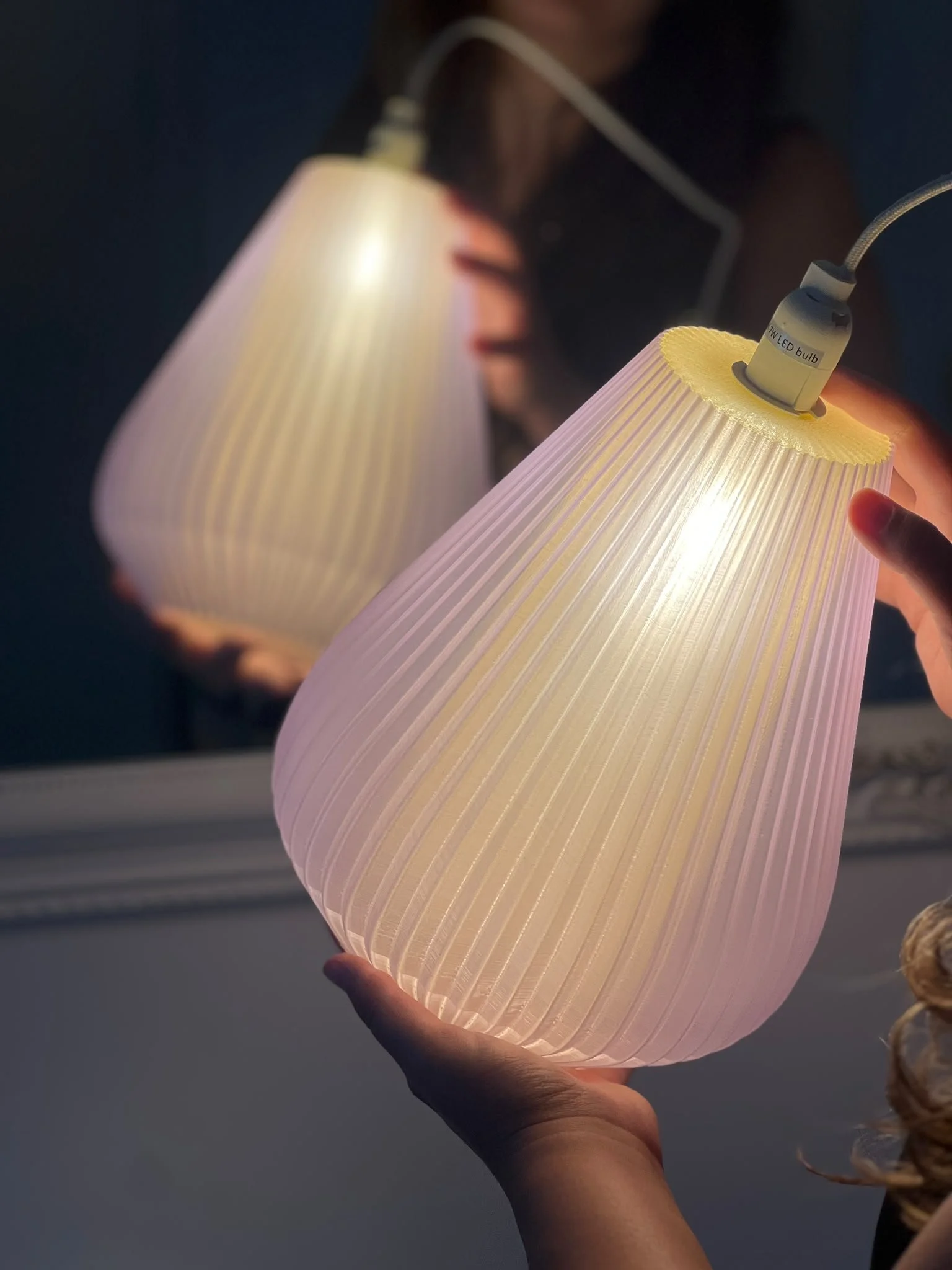 Yellow decorative table lamp with a ribbed glass shade on a wooden base, placed on a white surface.
