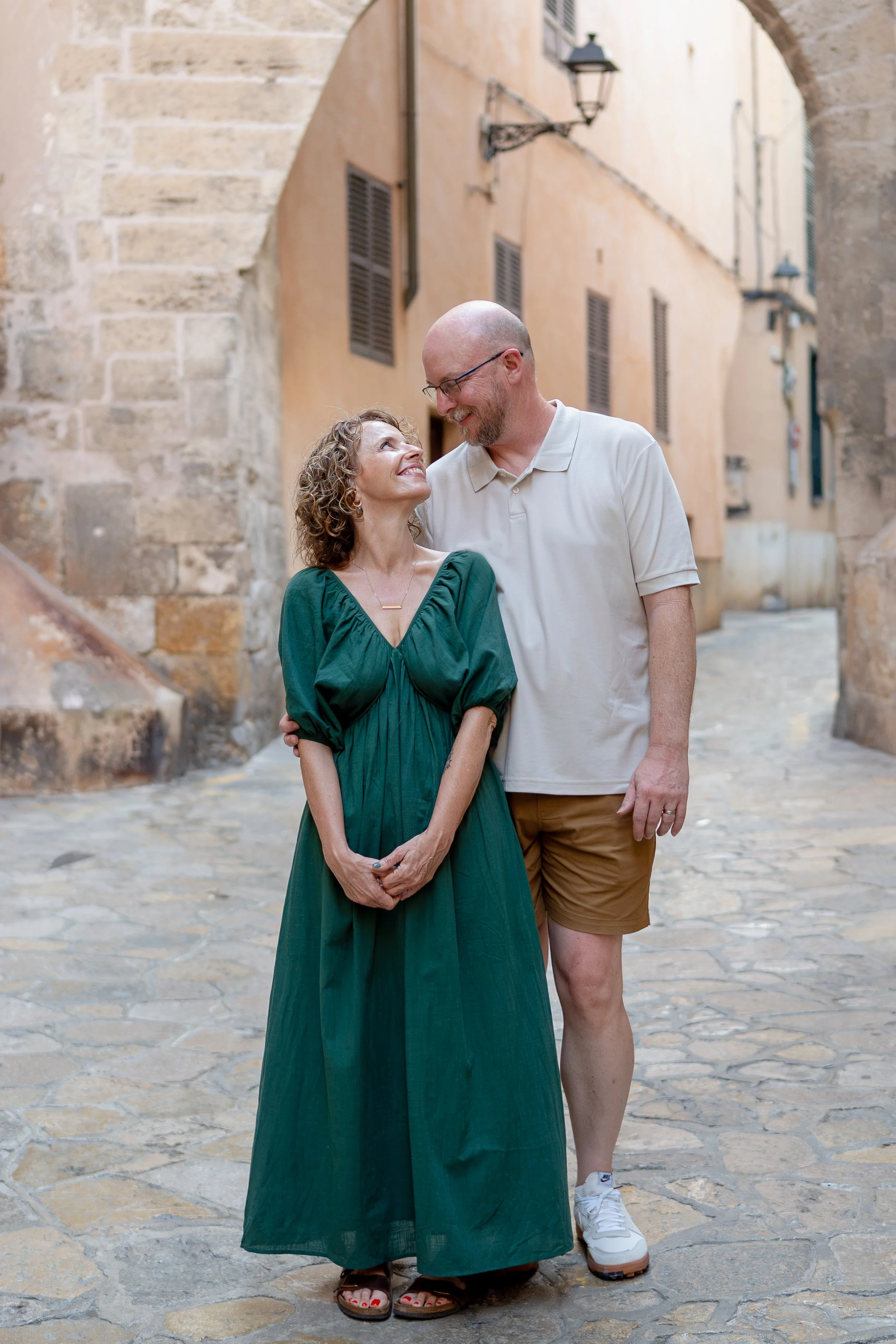 Romantic couple looking into each other's eyes in a charming historic street in Palma de Mallorca, Spain, during a natural couples photography session