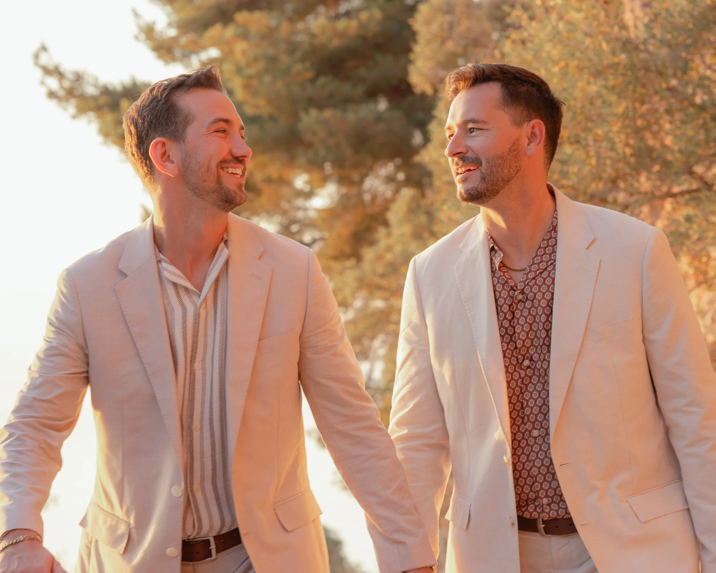 Romantische koppelfotoshoot op Mallorca tijdens zonsondergang, waarbij twee mannen elkaar liefdevol aankijken tijdens een ontspannen en natuurlijke fotosessie