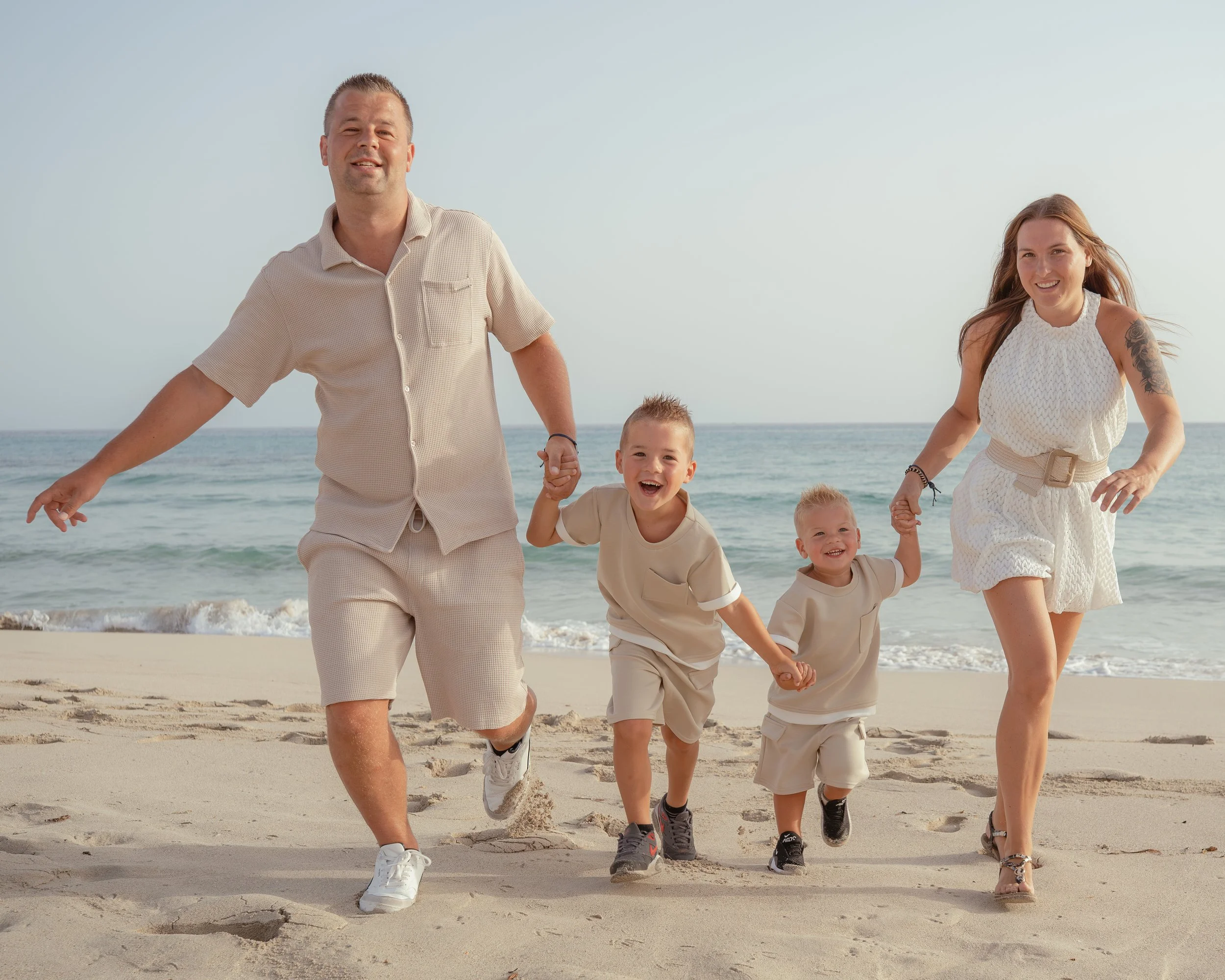 Familie fotoshoot met gezin met 2 kleine zoons die rennen over het strand op Mallorca