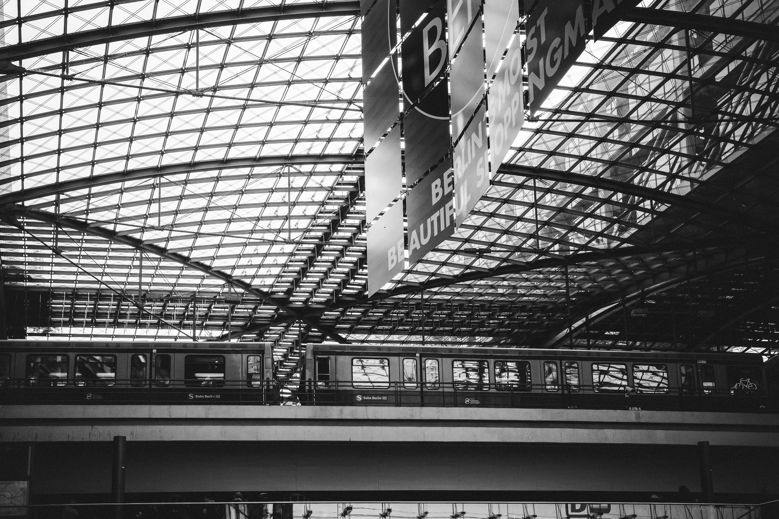 Dworzec i stalowa konstrukcja w Berlinie - czarno-biała fotografia infrastruktury, dachu, torów i miejskiego rytmu.