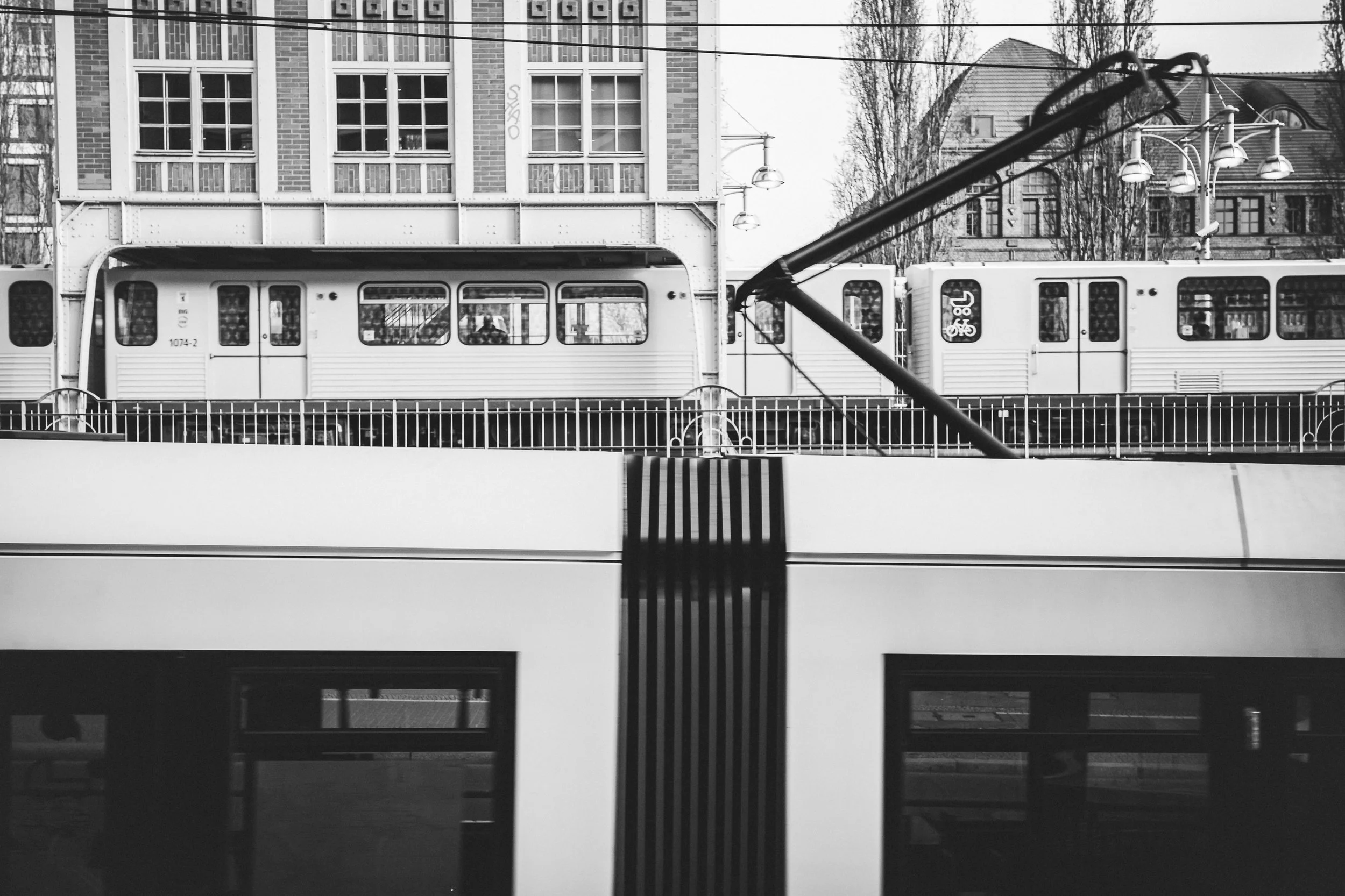 Czarno-biała fotografia Berlina - kolej miejska, fasada budynku i uporządkowany rytm miejskiej infrastruktury.