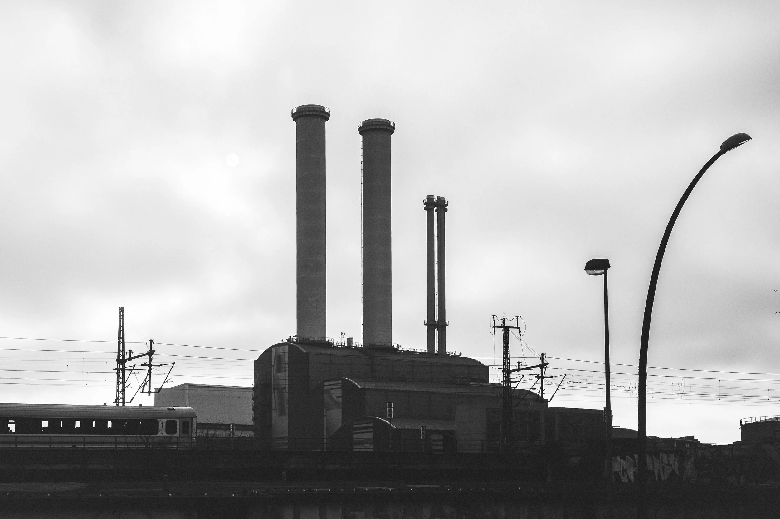 Elektrownia i kominy w Berlinie - czarno-biała fotografia industrialnej architektury i surowego krajobrazu miasta.