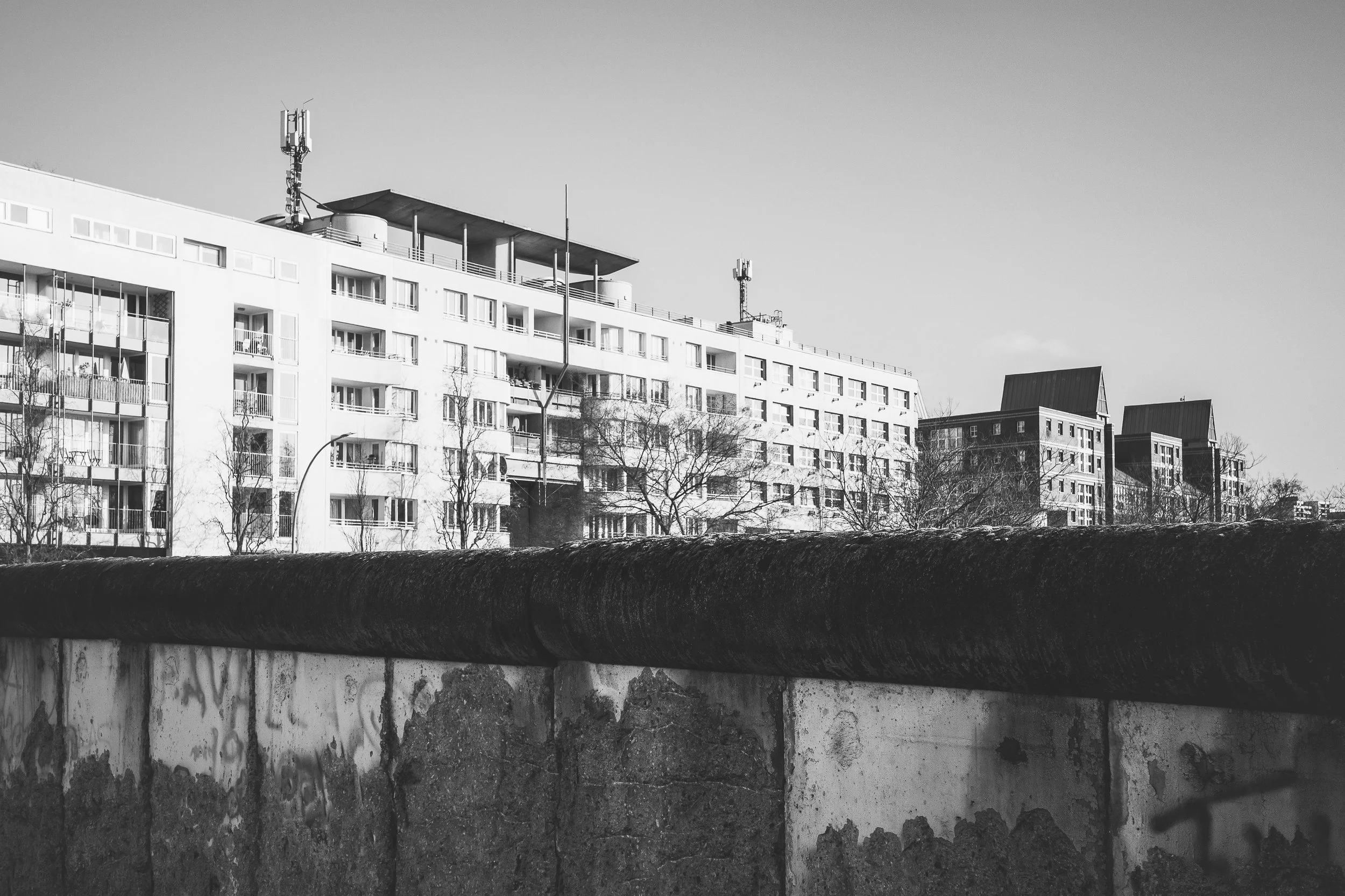Berlińska zabudowa za betonowym murem - czarno-biała fotografia miasta, warstw, granic i architektonicznego dystansu.