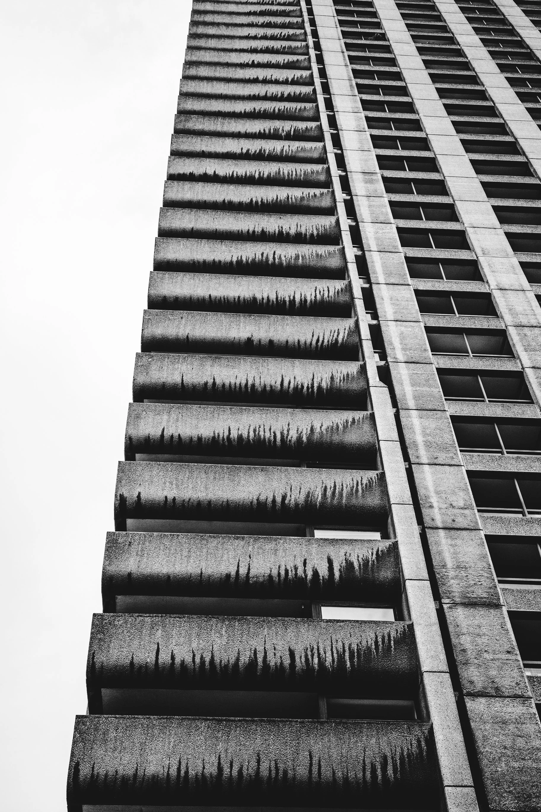 Wysoka elewacja Barbican Centre - czarno-biały kadr architektury z mocnym rytmem pionów i balkonów.