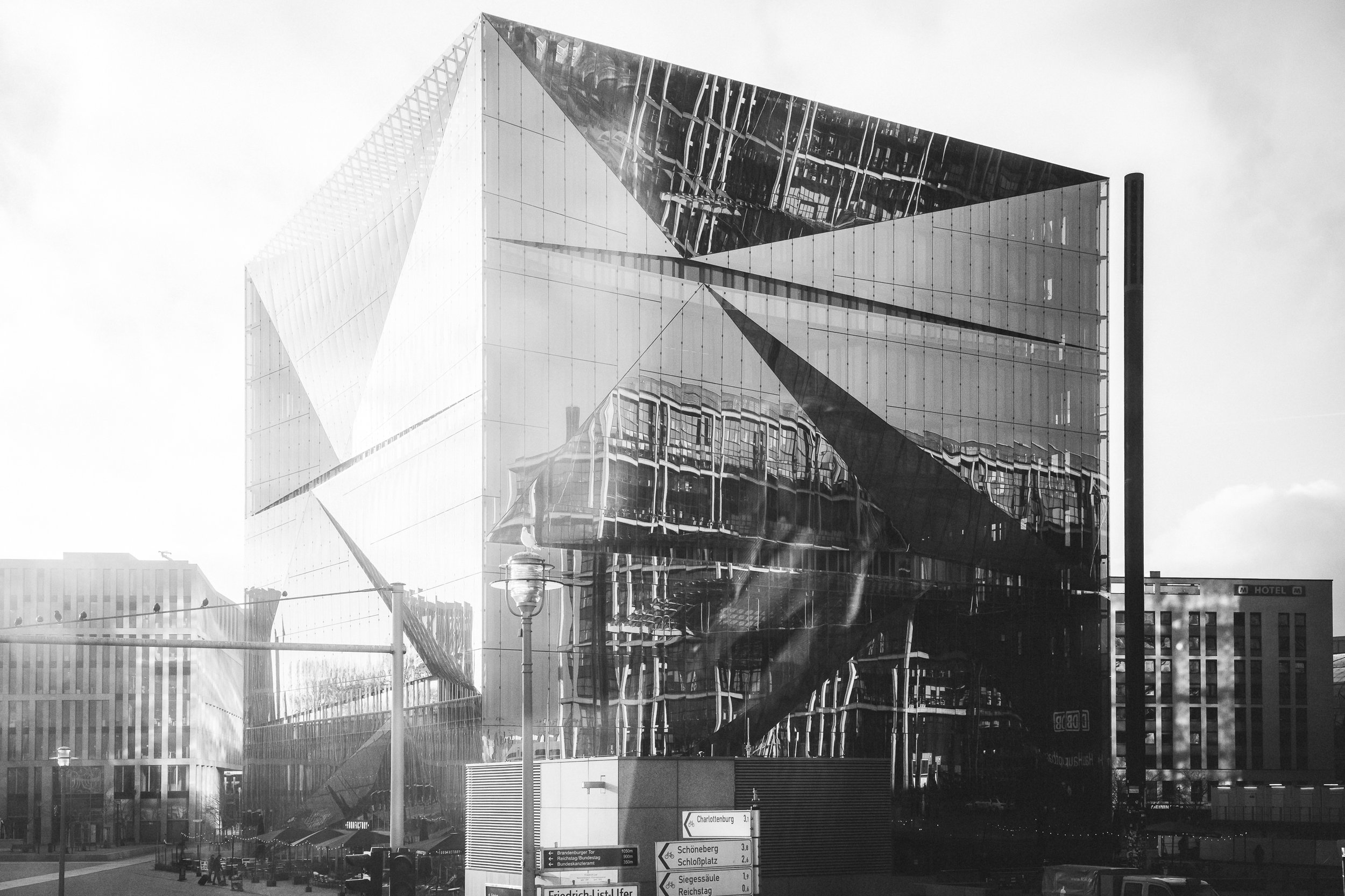 Nowoczesna bryła architektoniczna w Berlinie - czarno-biała fotografia szkła, światła i ostrej geometrii fasady.