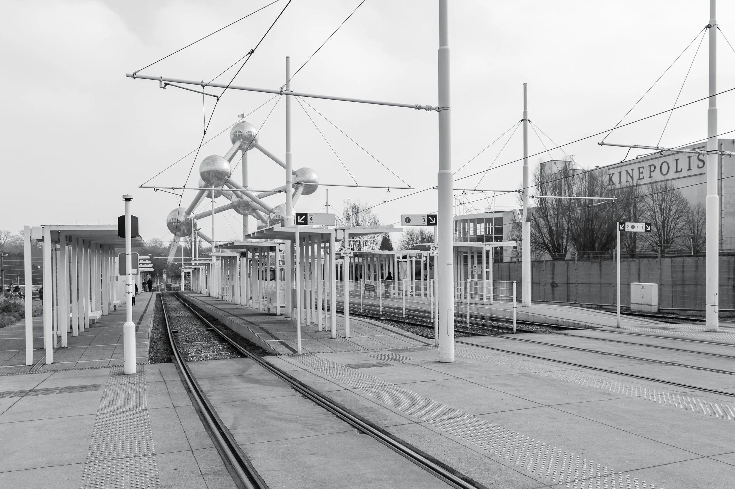 Atomium i otaczająca przestrzeń w Brukseli - czarno-biała fotografia architektury, konstrukcji i miejskiego porządku.