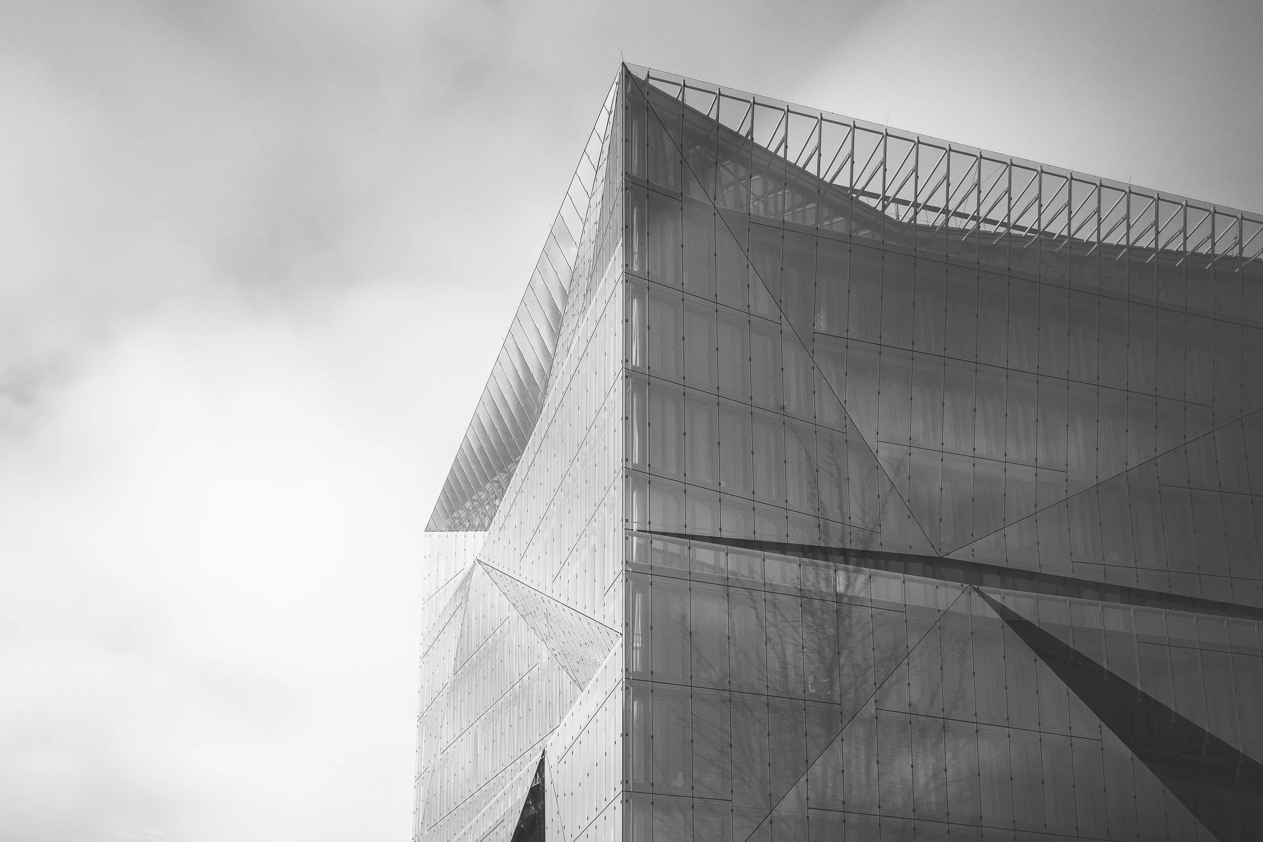 Szklana fasada budynku w Berlinie - czarno-biała fotografia architektury skupiona na kącie, odbiciu i strukturze.