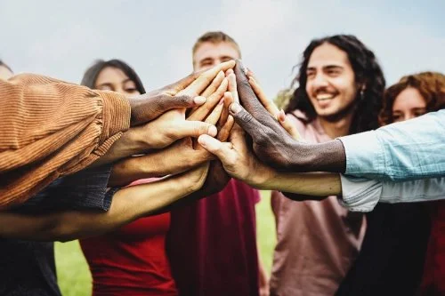 DJs legen ihre Hände zusammen in der Mitte, symbolisiert Zusammenhalt und Gemeinschaft.