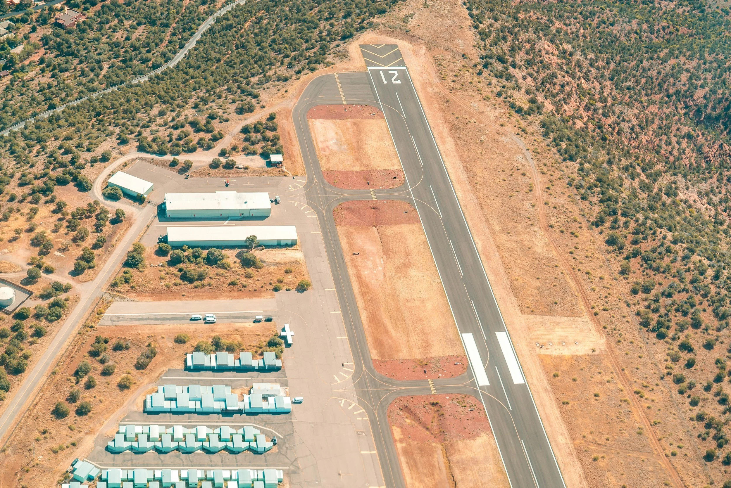 A high-resolution aerial shot of a military base, power plant, or airport with visible fencing or security perimeters.