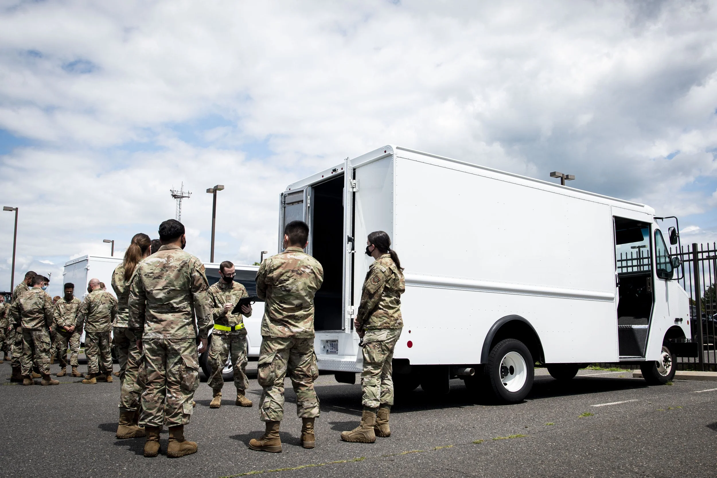 People in army uniforms in front of a white truck