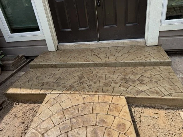 Stamped concrete walkway with a semi-circular pattern leading to a front door.