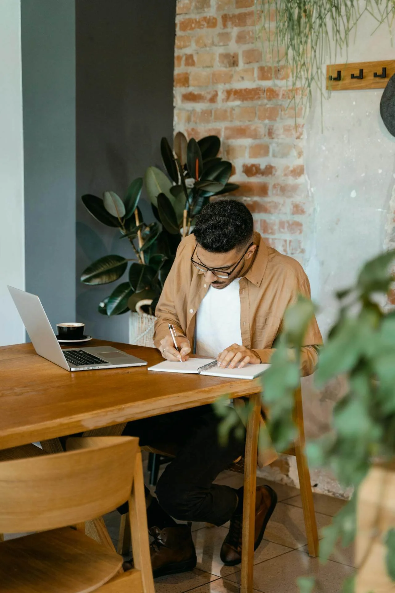 Man seated at a table journalling to calm his mind