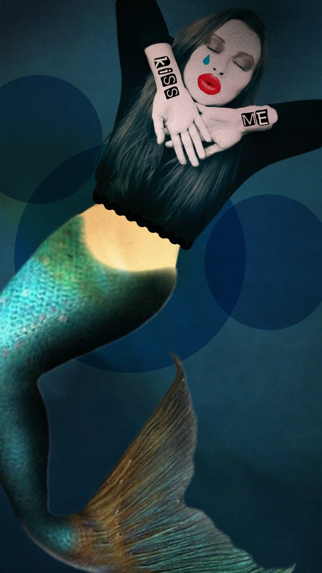 Kombination aus einer menschlichen Frau mit Mermermotiv, die ein schwarzes T-Shirt trägt, und einem Fischschwanz, die Pose ist künstlerisch. Die Frau hat lange Haare, trägt rote Lippen, einen Widschlag, und hat Aufkleber mit den Worten "KISS" und "ME" auf den Armen sowie ein Wassertropfen im Gesicht.