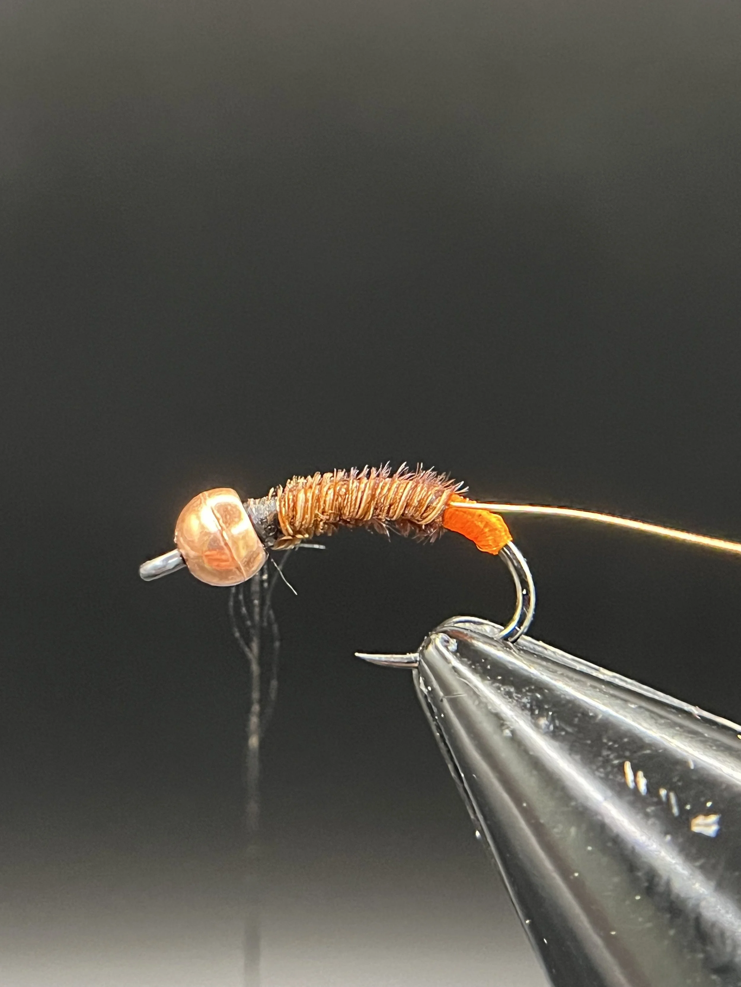 Wrap the pheasant tail forward to the bead and tie off. Make sure to leave some of the orange floss exposed at the hook bend to create a hotspot.