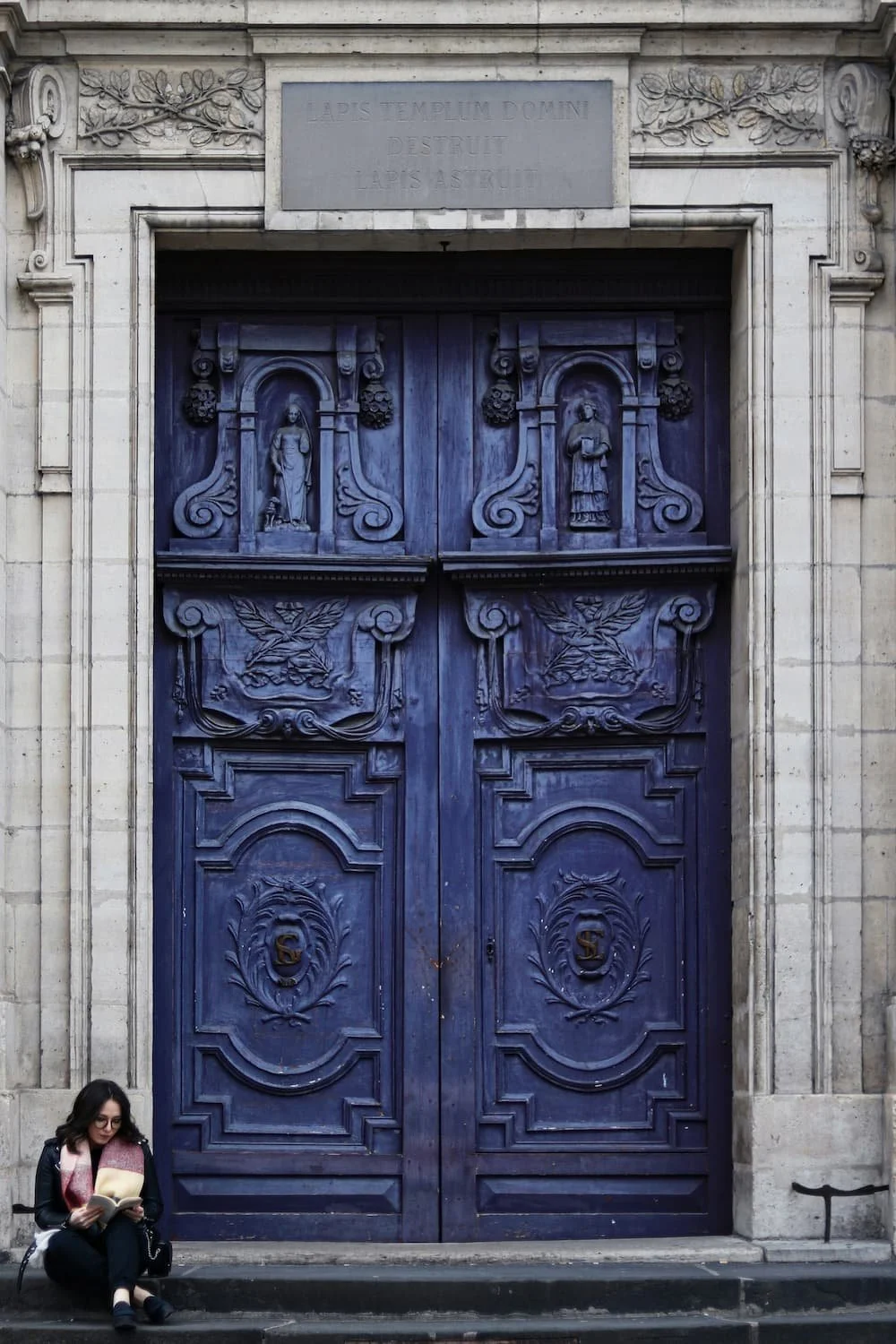 blue paris door with woman sitting on step