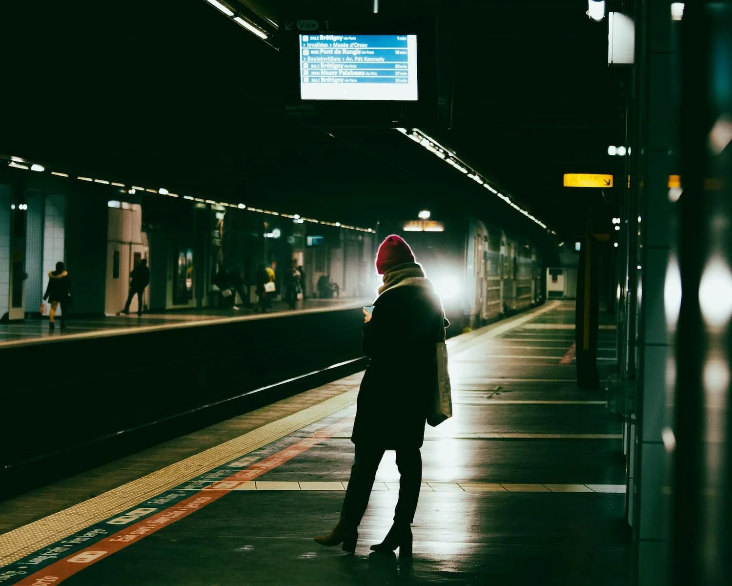 woman on metro platform at night