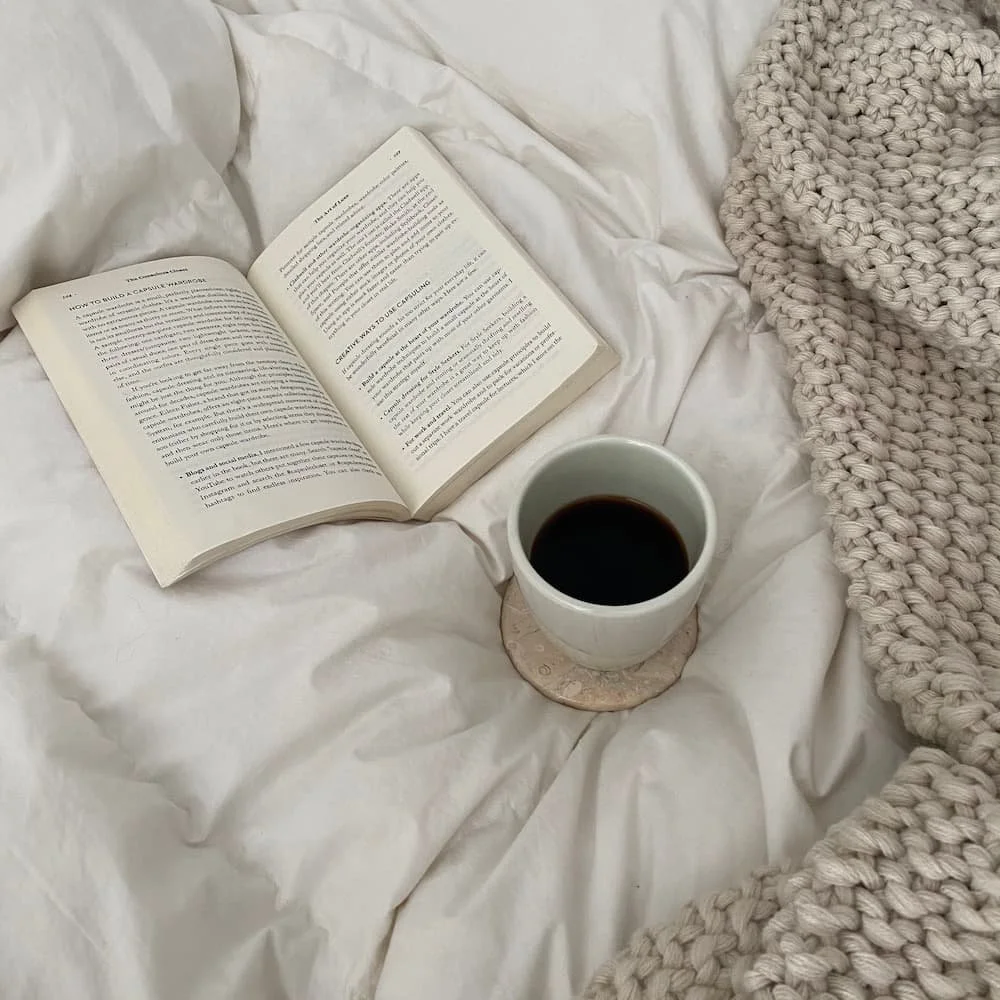 bed with book and knitted blanket
