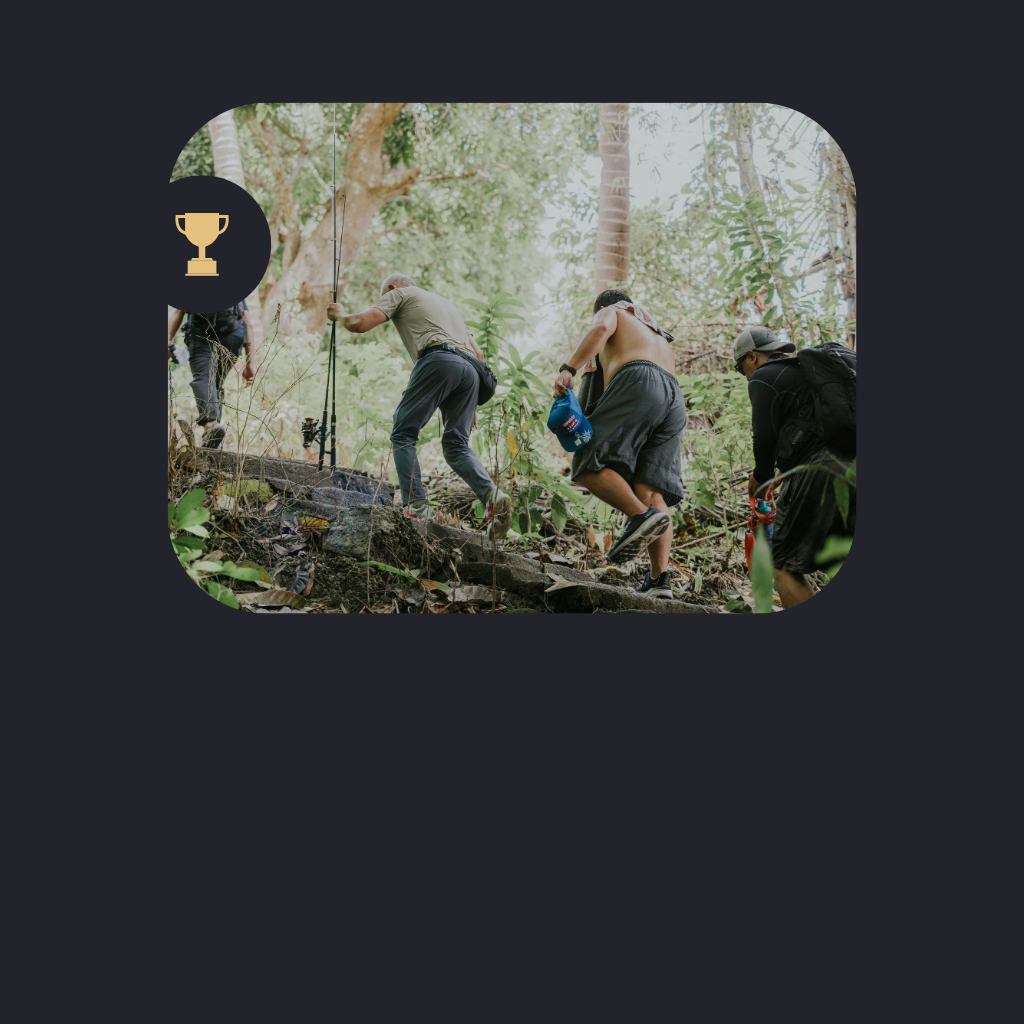 People hiking up a rocky trail in a dense forest.