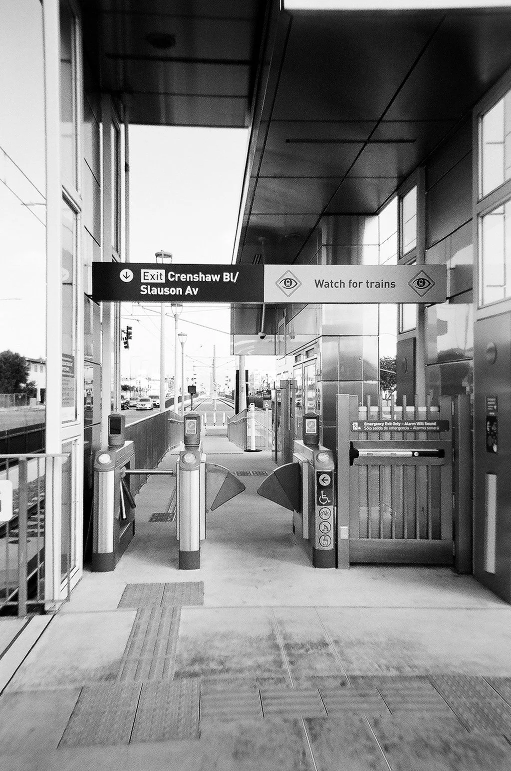 Entrance to a train station with gates, signs indicating exit to Crenshaw Blvd and Slauson Ave