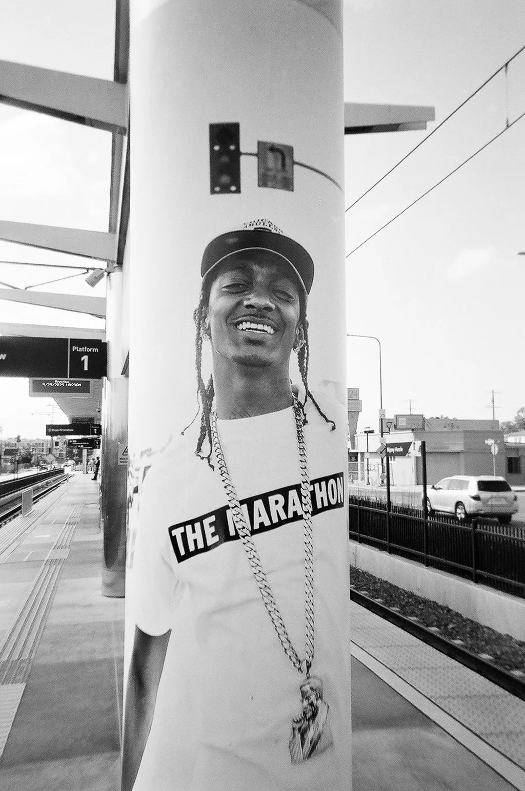 Black and white photo of a Nipsey Hussle poster The Marathon Continues