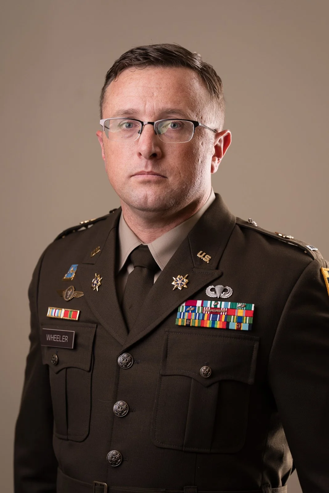 Portrait of a man in military uniform with glasses, wearing medals and ribbons