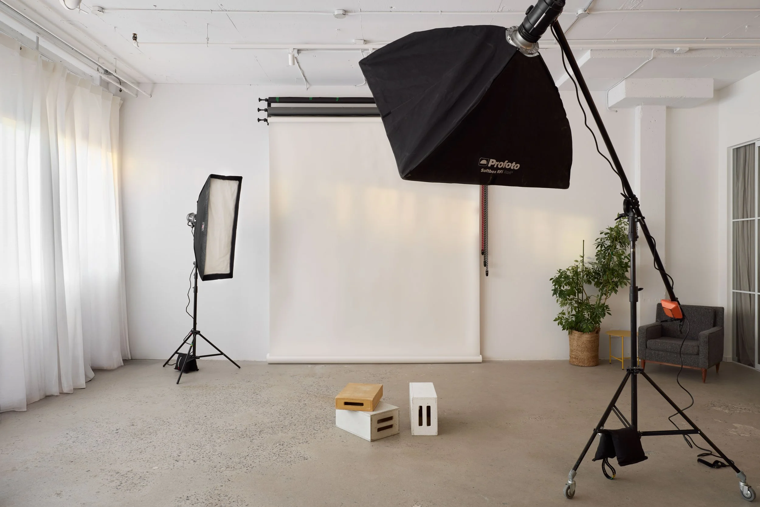 Studio lumineux avec équipement Profoto sur trépied, fond blanc, couché de soleil, chaleureux