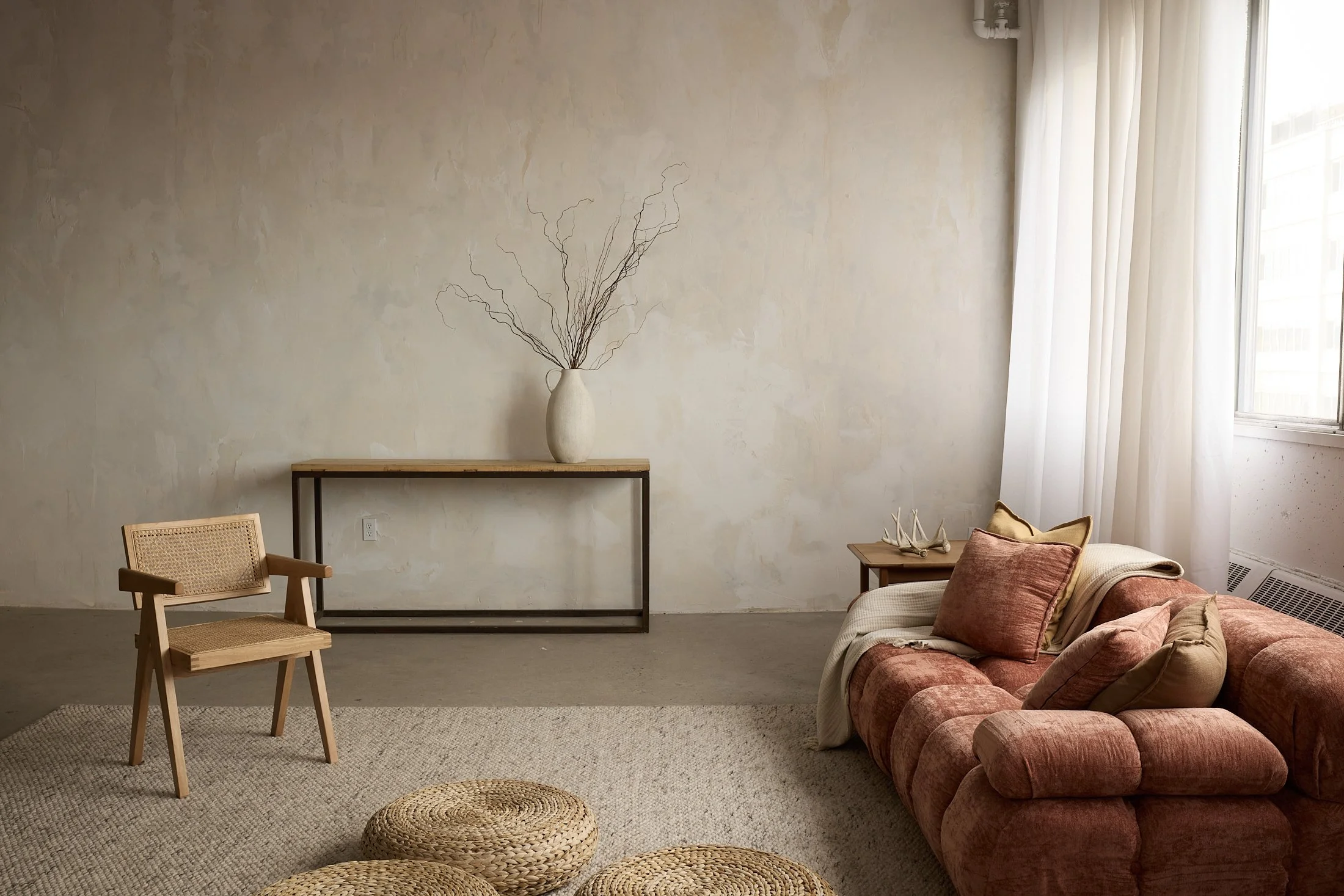 Studio photo rustique, divan, lumineux, beige, chaleureux, mur texturé, bois, lumière douce, relaxation, confort, sérénité