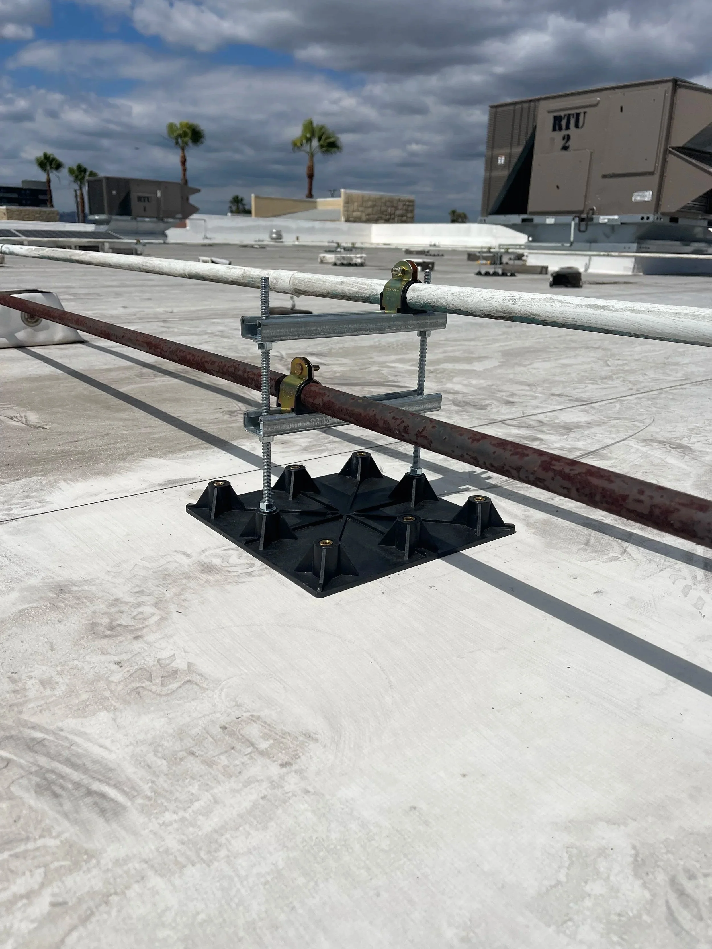 Commercial rooftop pipe support base with Unistrut supporting rooftop piping