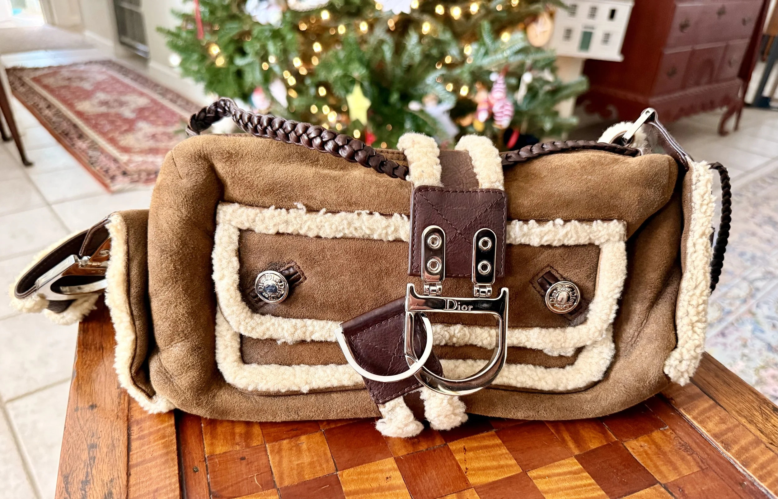 Shearling crossbody bag styled for winter travel, photographed indoors with holiday decor.