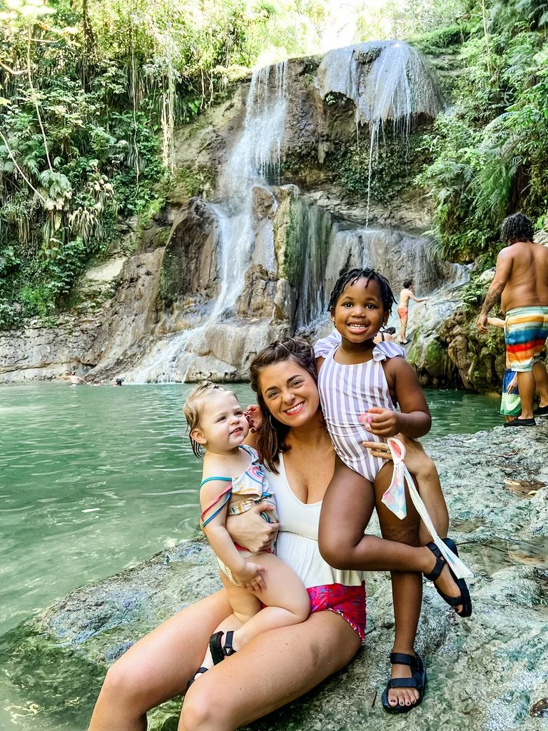 Just Another Wagner Adventure | A woman and two young girls enjoying at a waterfall with a pool, surrounded by lush green foliage. Gozalandia Falls in Puerto Rico.