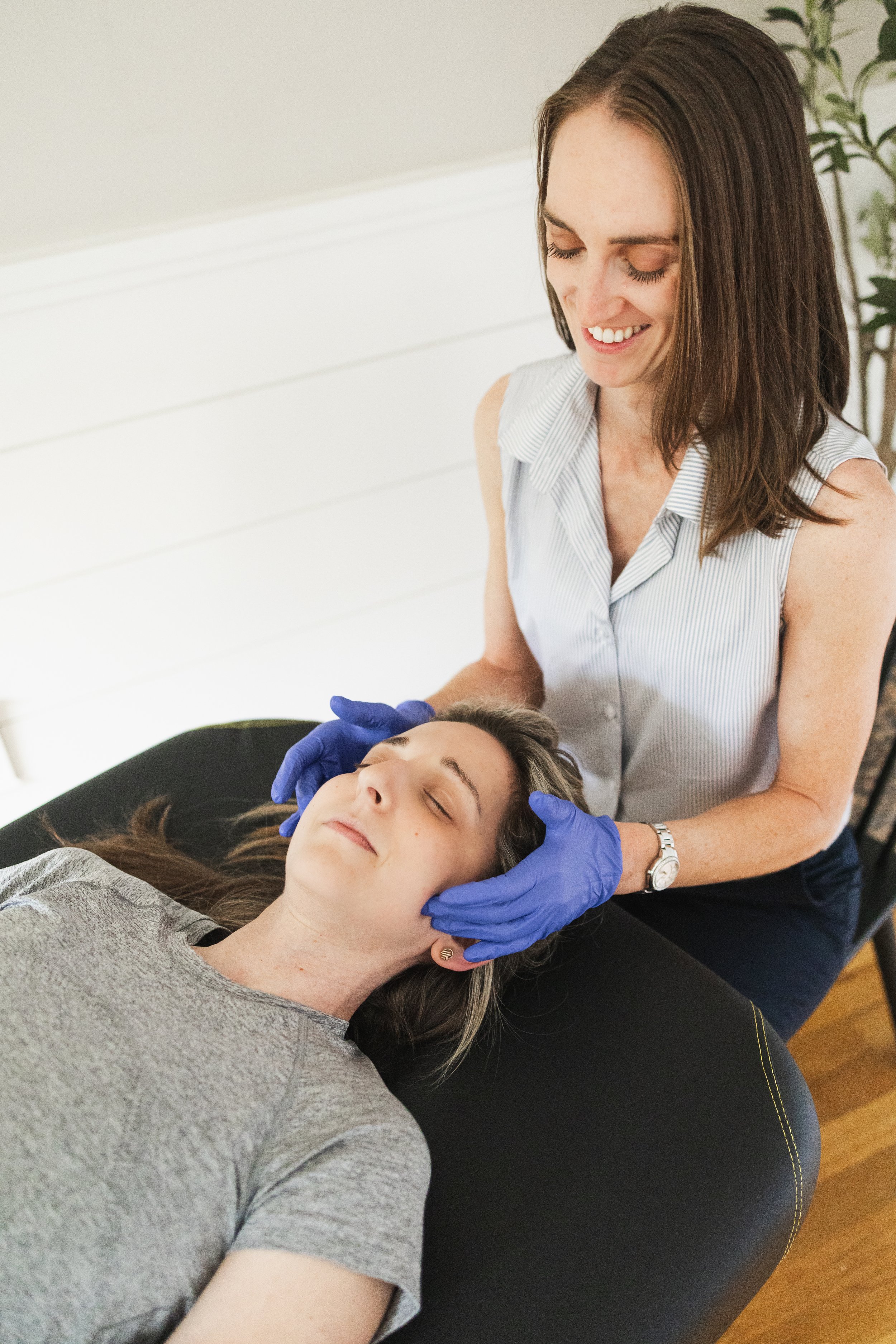 Licensed Physical Therapist Julia Cross assists patient in south shore office with hands on treatment