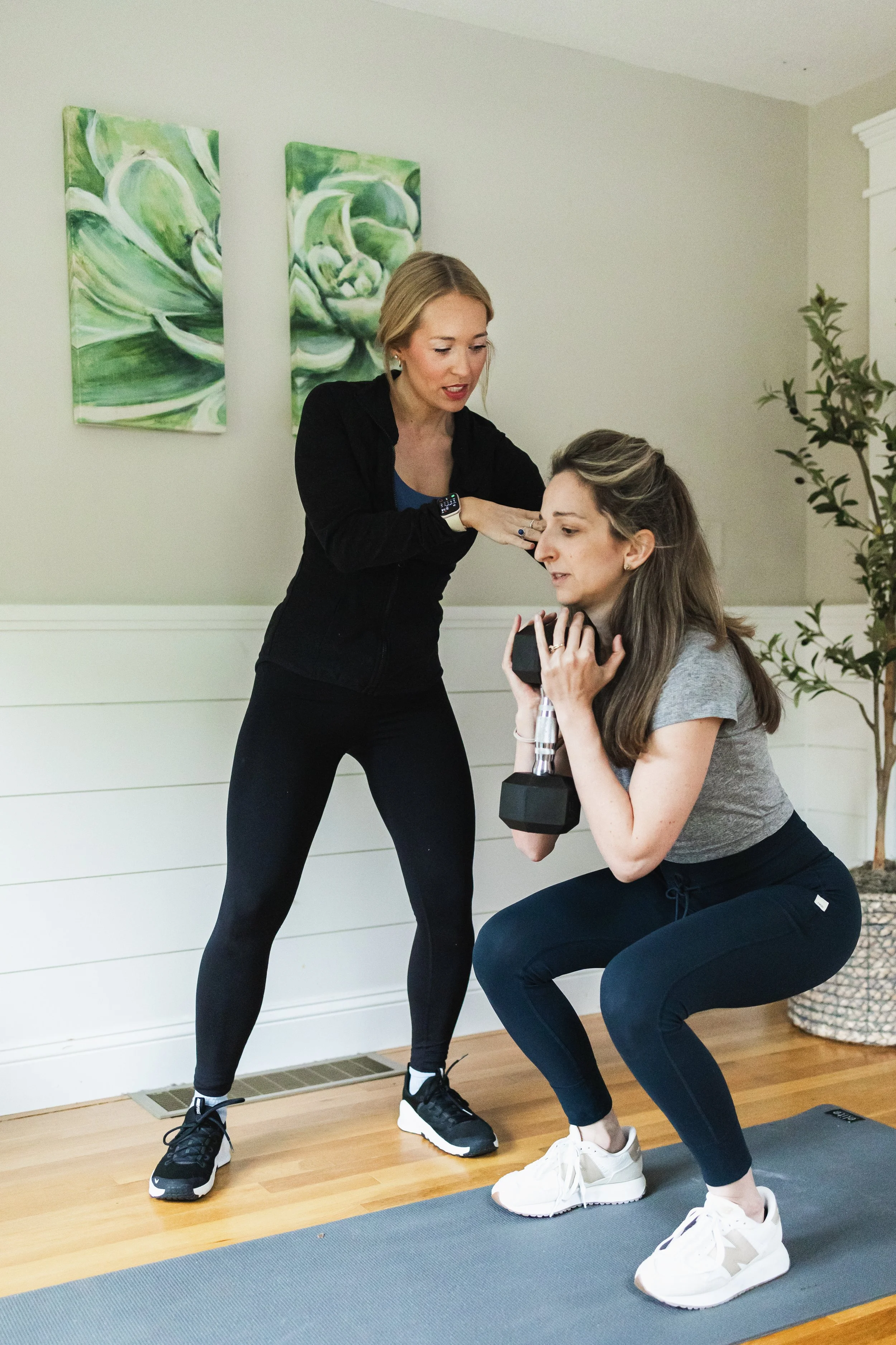 Diana Cross, Certified Personal Trainer, guides client on proper squatting technique in south shore office.