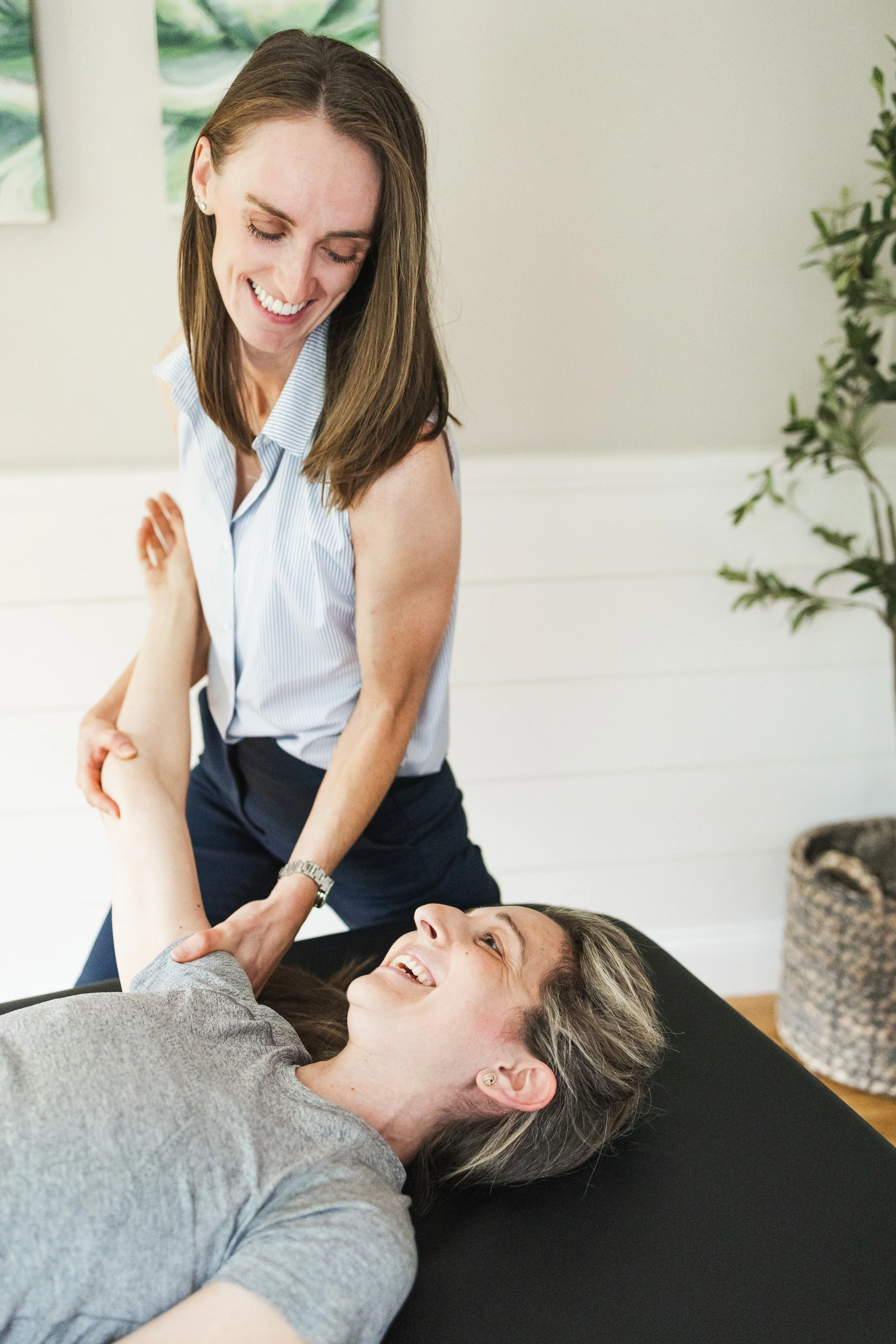 Licensed Physical Therapist Julia Cross assists patient in south shore office with hands on stretching.