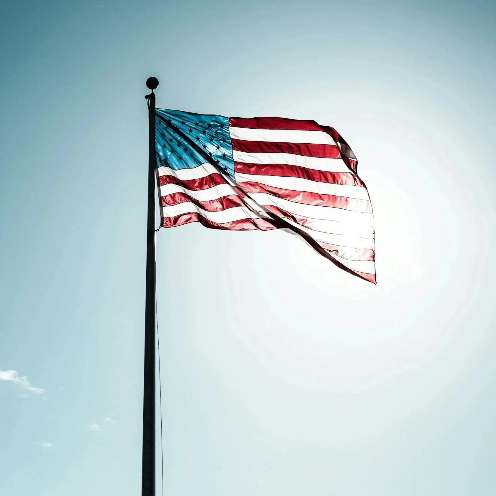 American flag waving in the wind against a clear sky.
