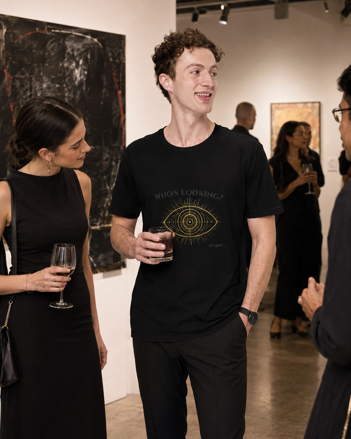 People socializing at an art gallery, holding glasses of wine, with artwork on the walls in the background.
