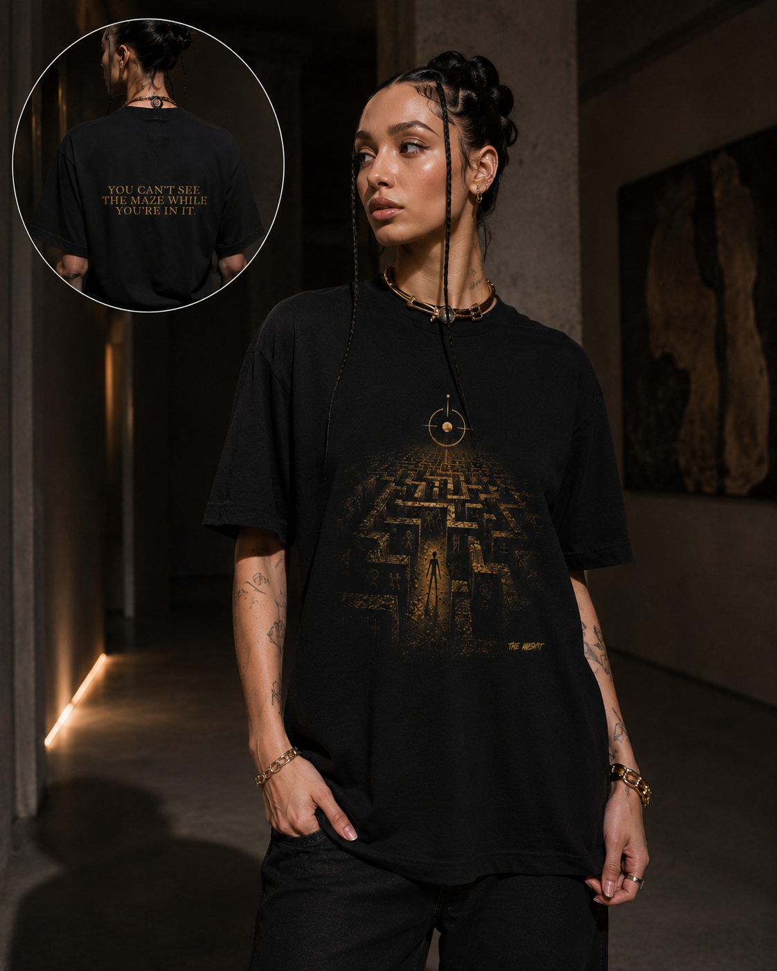 Black graphic T-shirt worn by a woman in an art gallery, featuring The Maze artwork with a figure inside the maze and the Viewpoint symbol above.