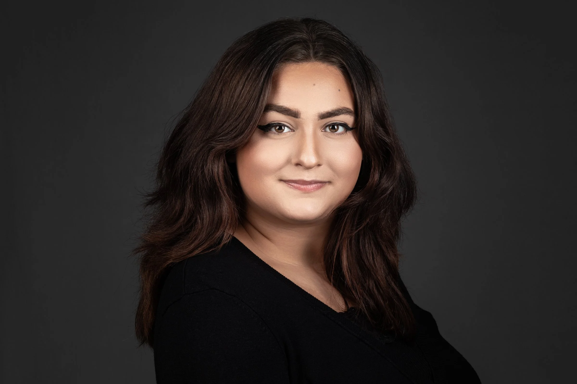 Professional headshot of woman with long dark hair and black top for business branding – Grand Valley Portraits