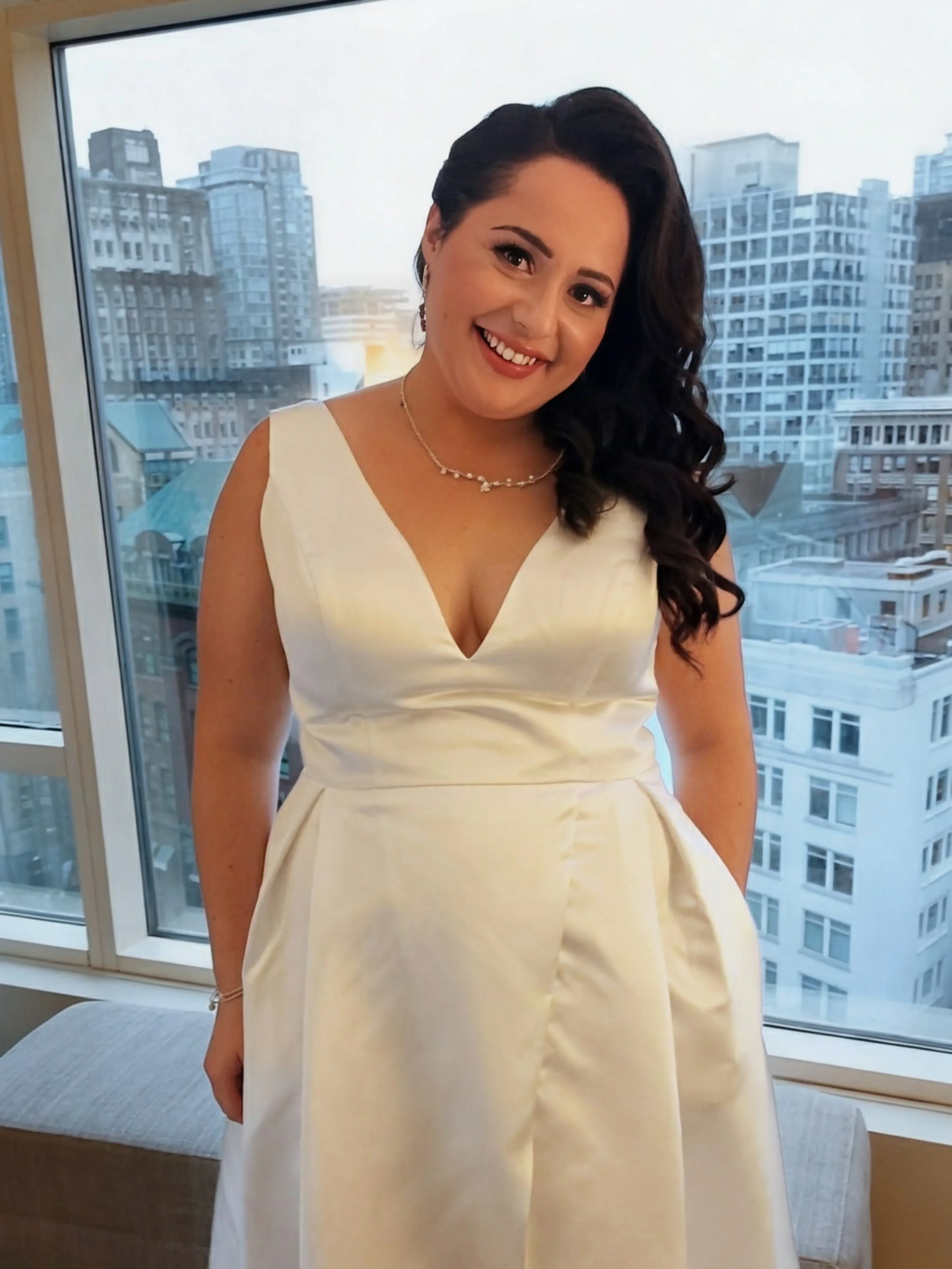 A woman with long, wavy brown hair had her hair styled by a bridal hairstylist in Vancouver, BC.