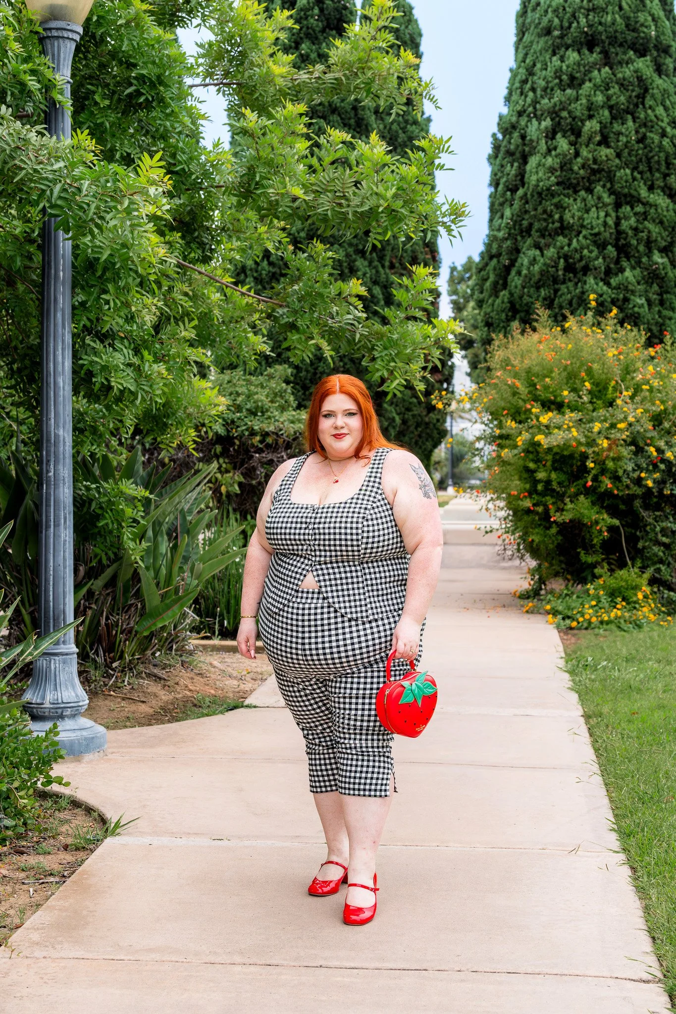 Plus size woman wearing gingham vest and matching capri leggings