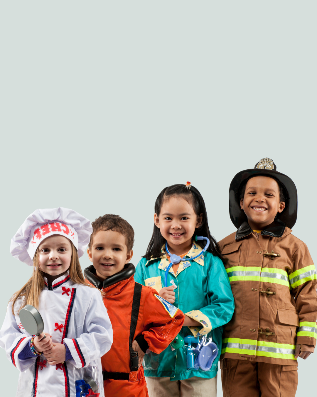 Four children dressed in various costumes representing different professions: a chef, a firefighter, a doctor, and a police officer, standing together and smiling.