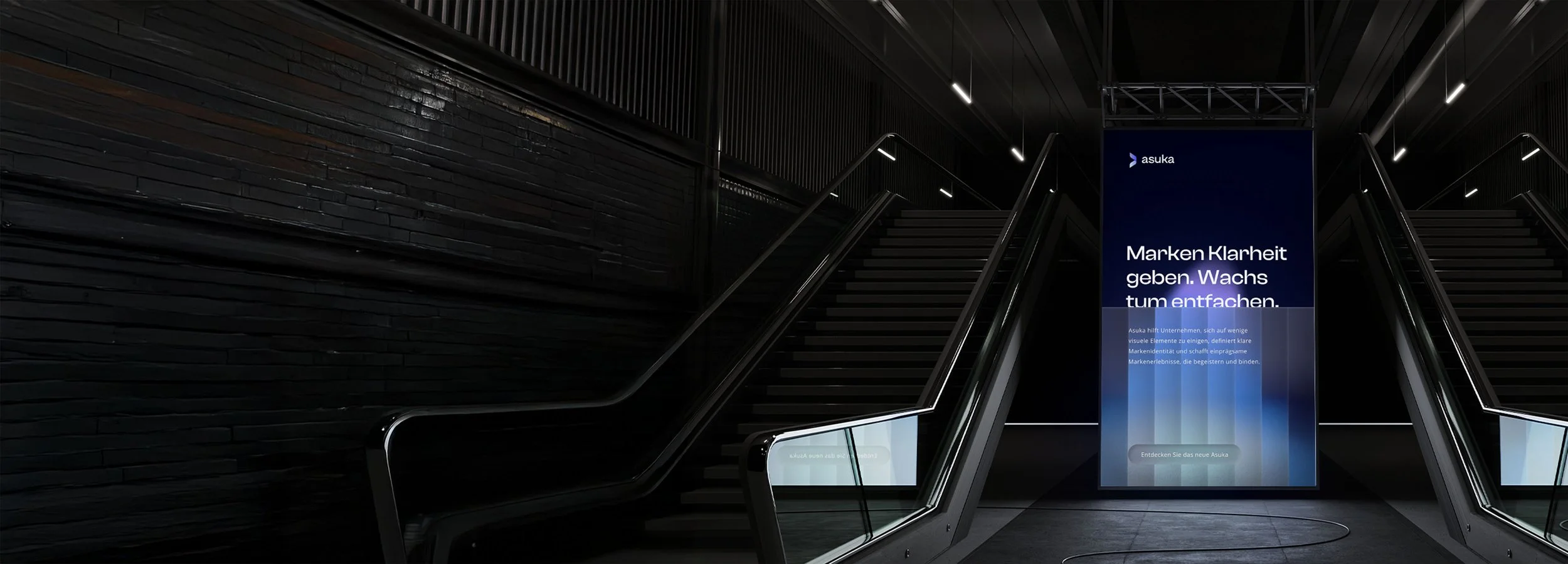 Illuminated stairwell with digital advertising column with text in German.